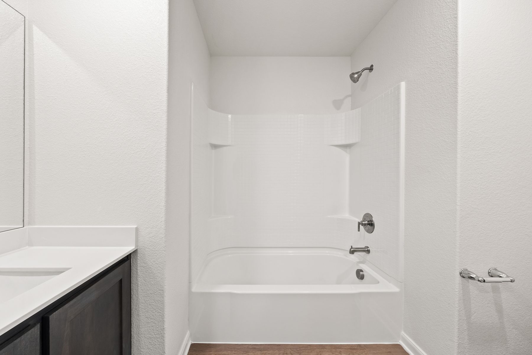 The secondary bathroom has a large shower-tub combo.