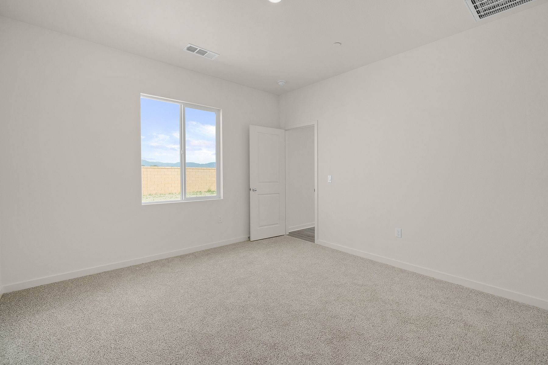 The master bedroom is spacious and has carpet.