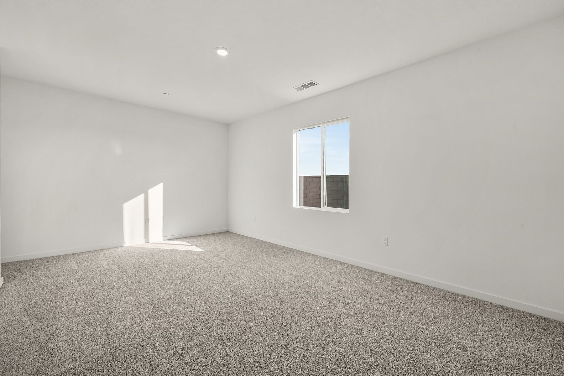 The master bedroom is spacious and has carpet.