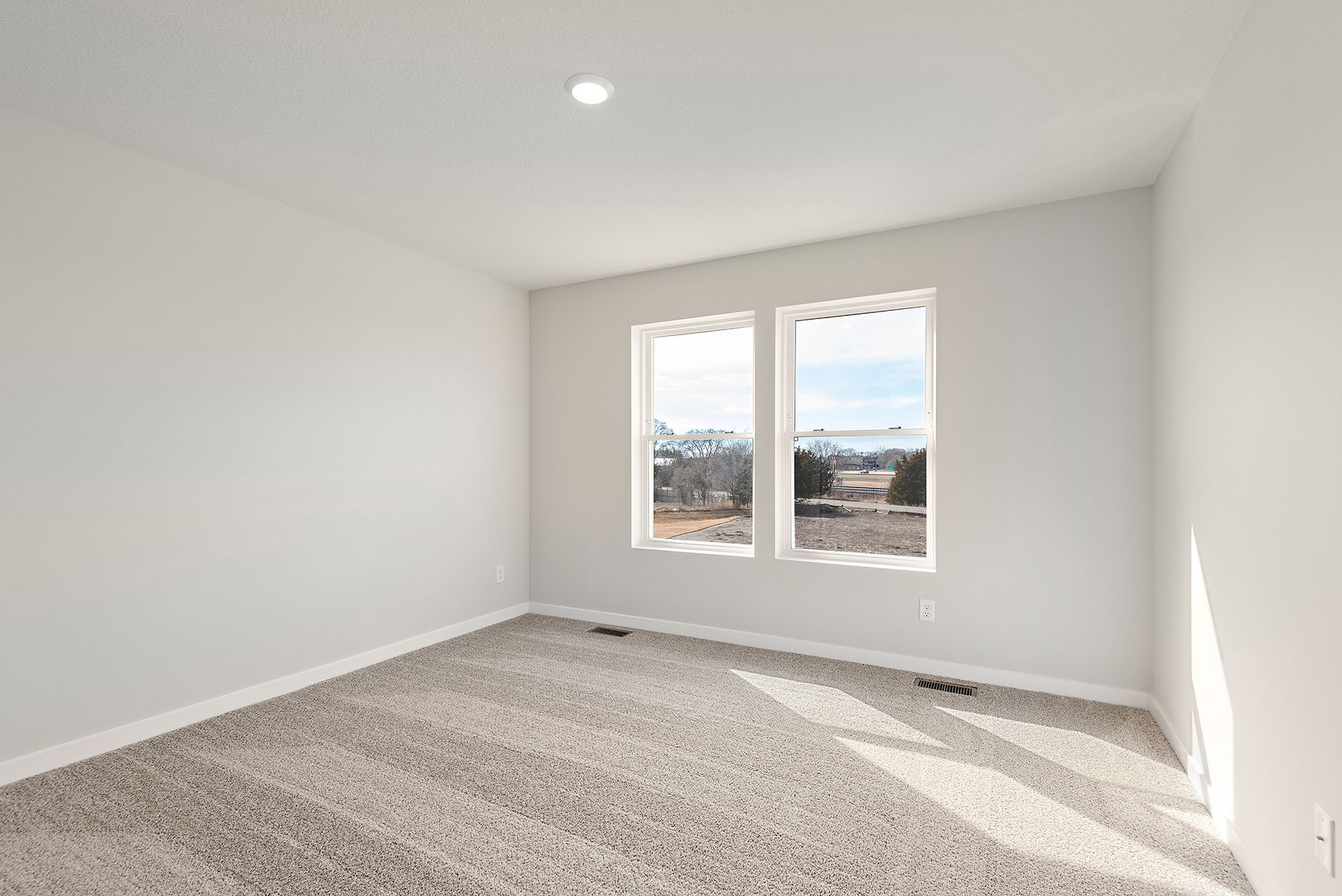The master bedroom is spacious and has carpet.