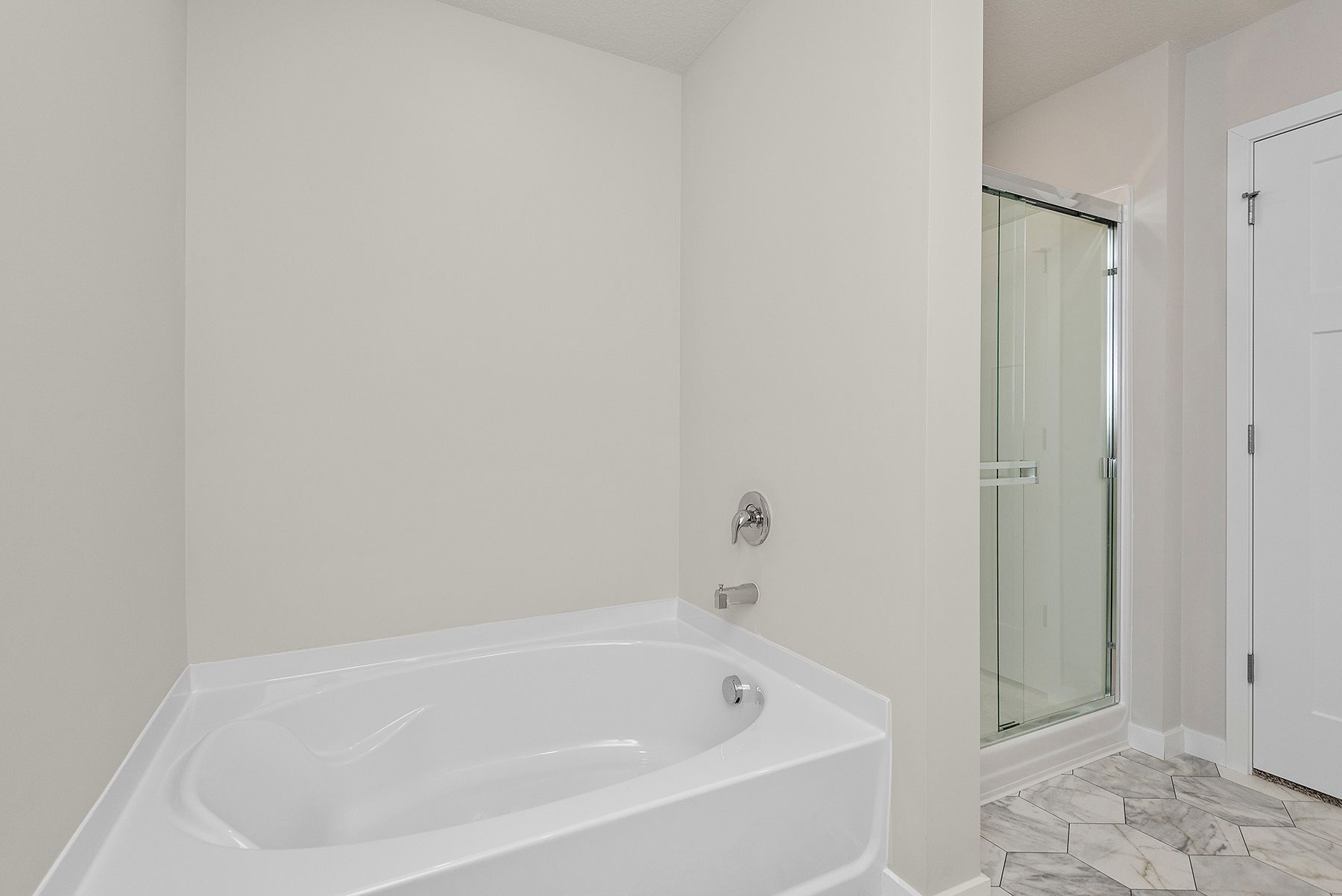The master bathroom has a dual sink vanity and a step in shower and soaking tub