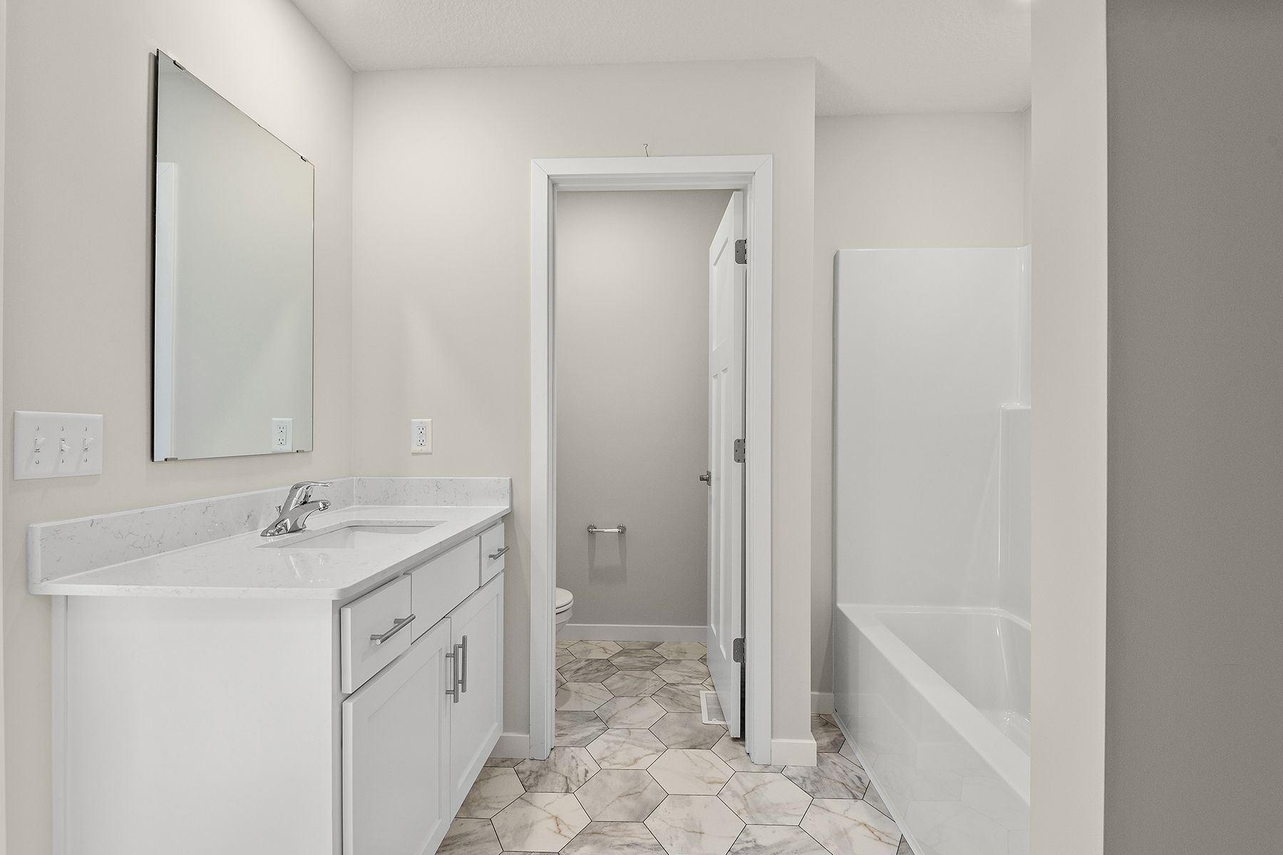 The master bathroom has a large vanity with a tub/shower combo.