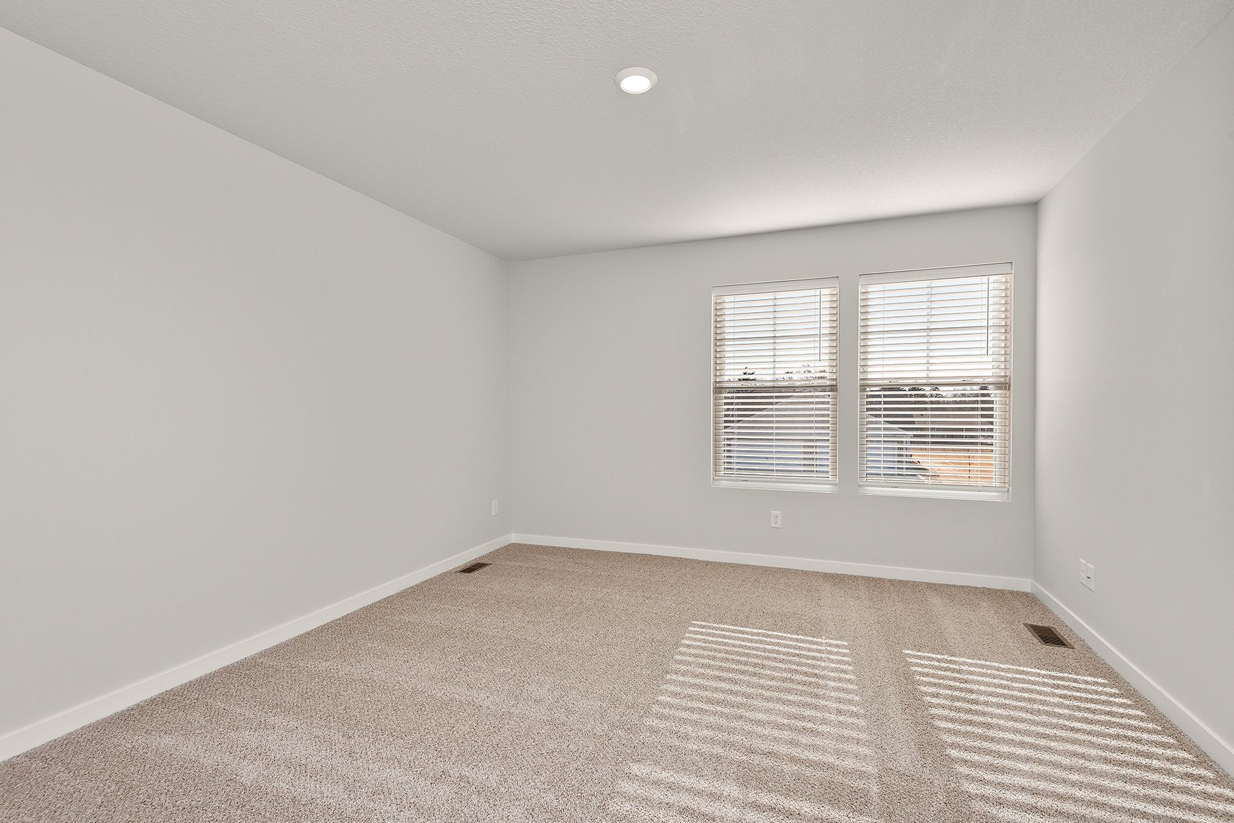 The master bedroom is spacious and has carpet.