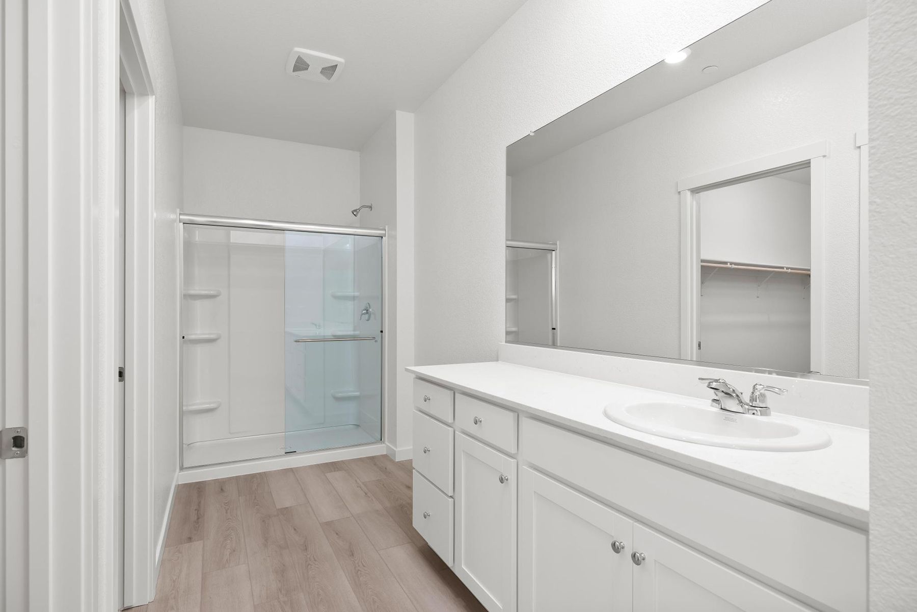 The master bathroom has a large vanity with a step in shower.