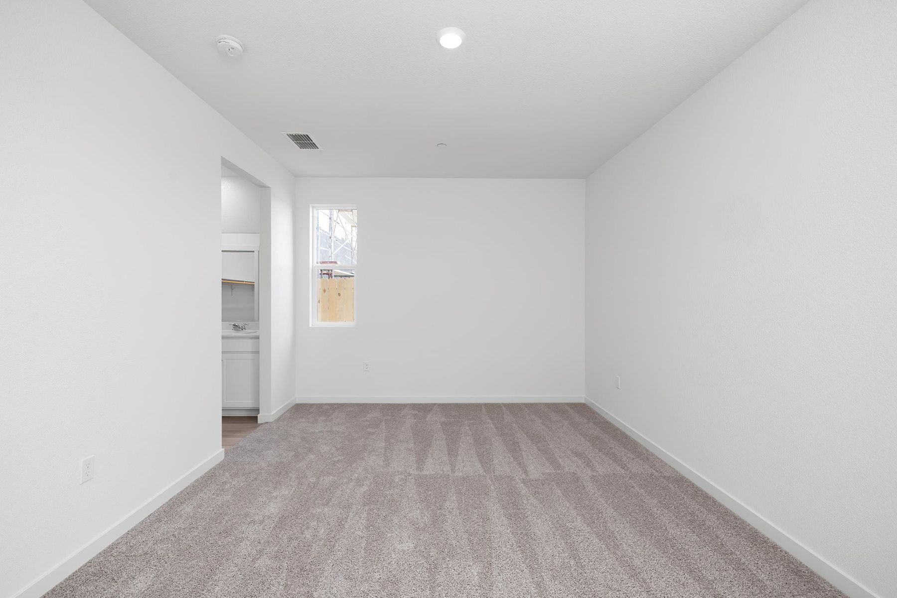 The master bedroom is spacious and has carpet.