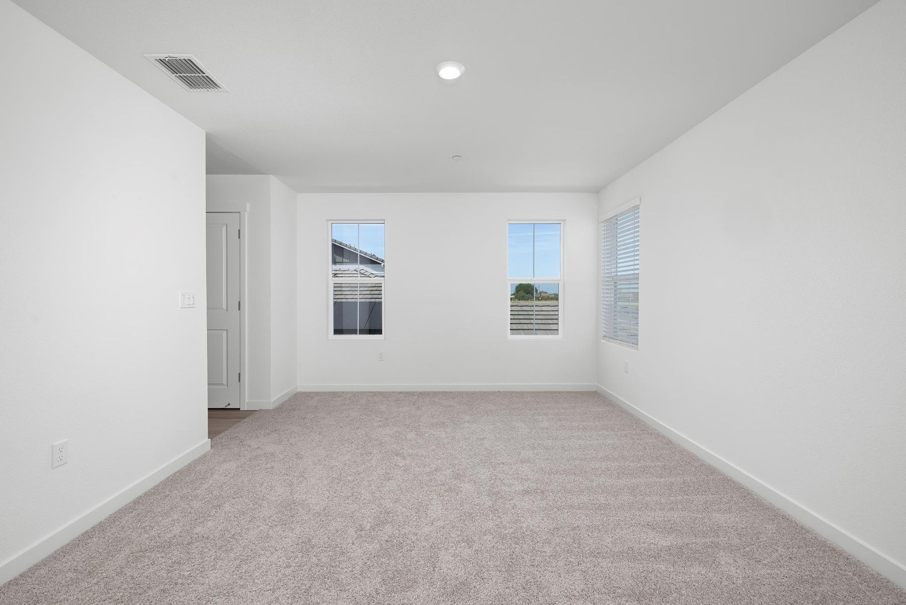The master bedroom is spacious and has carpet.
