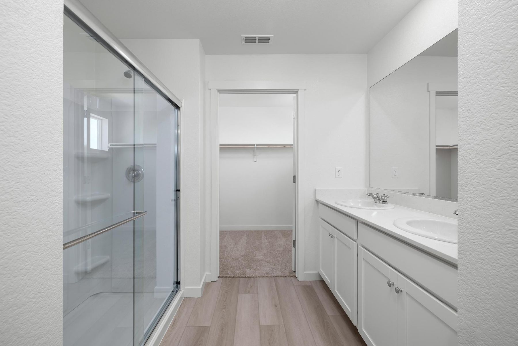 The master bathroom has a dual sink vanity and a step in shower.