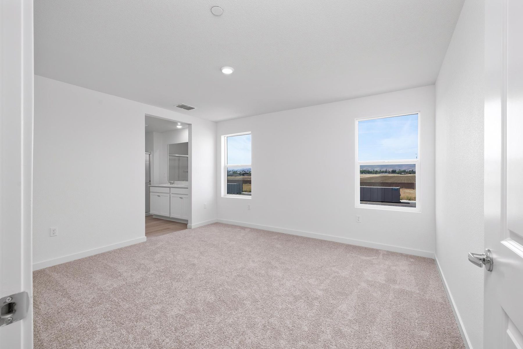 The master bedroom is spacious and has carpet.