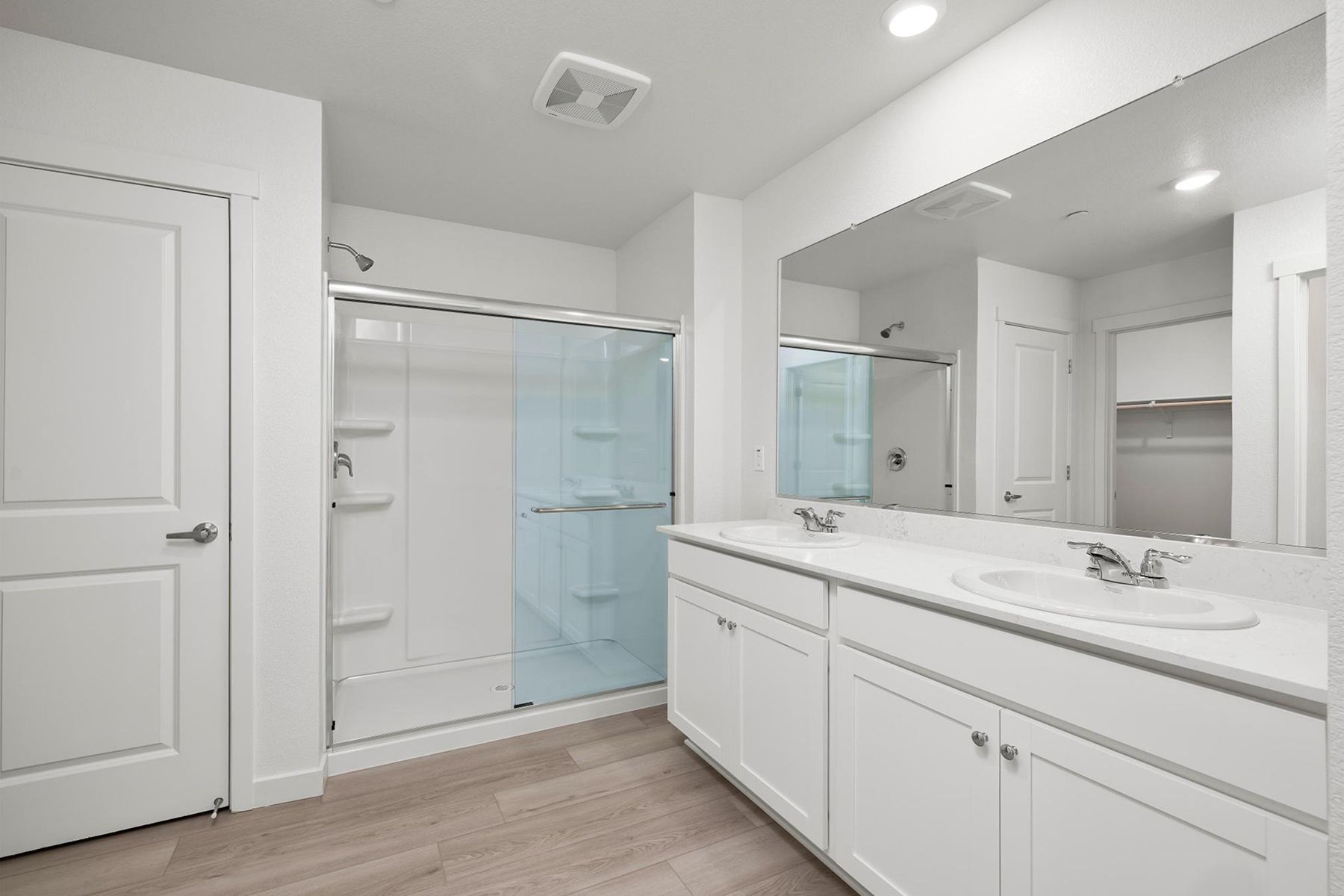 The master bathroom has a dual sink vanity and a step in shower,
