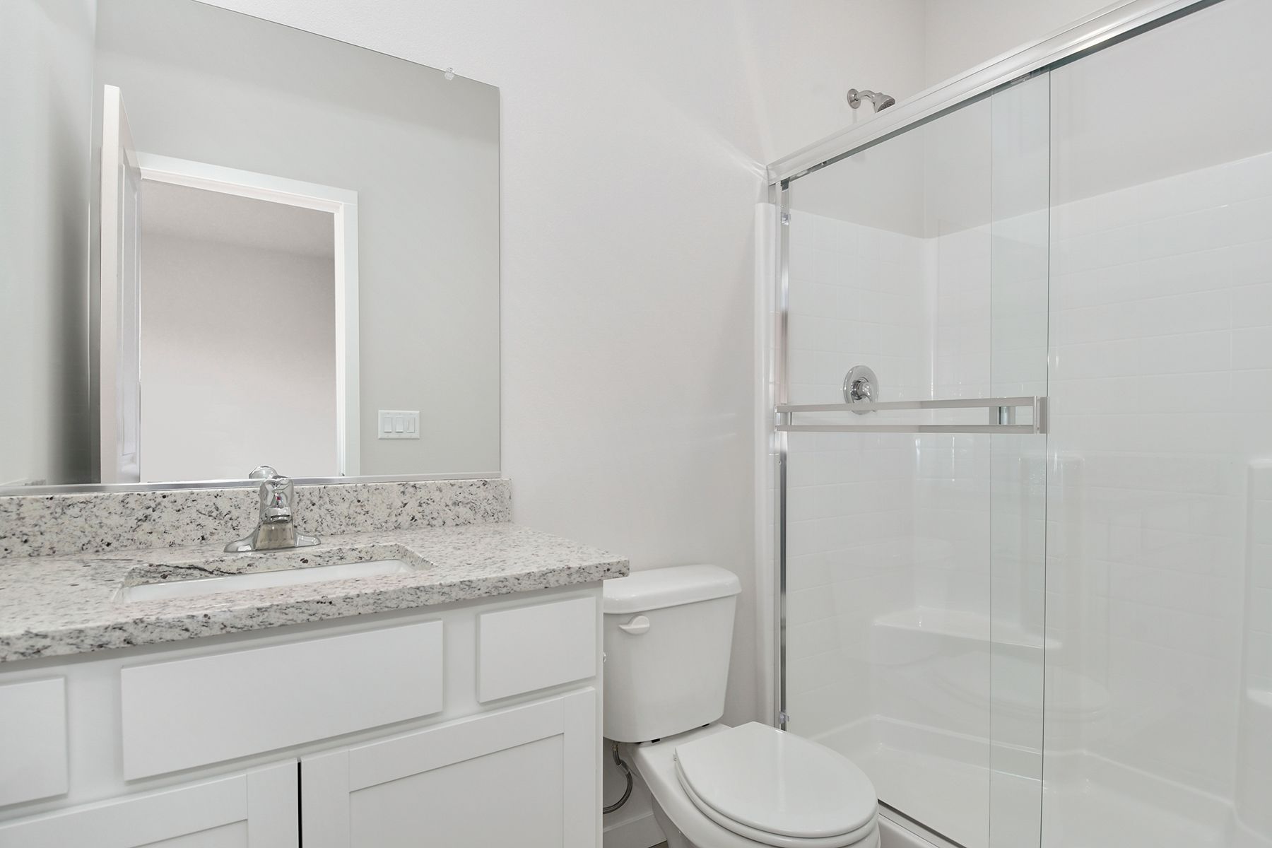 The master bathroom has a large vanity and a step in shower.