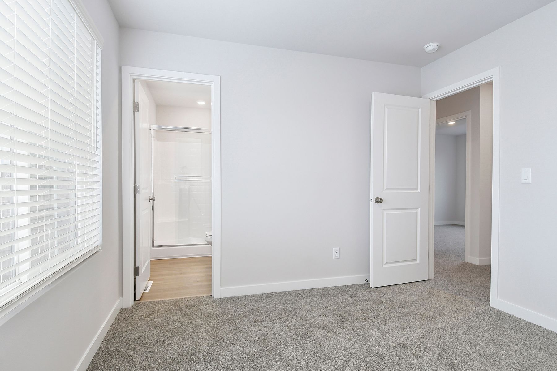 The master bedroom is spacious and has carpet.