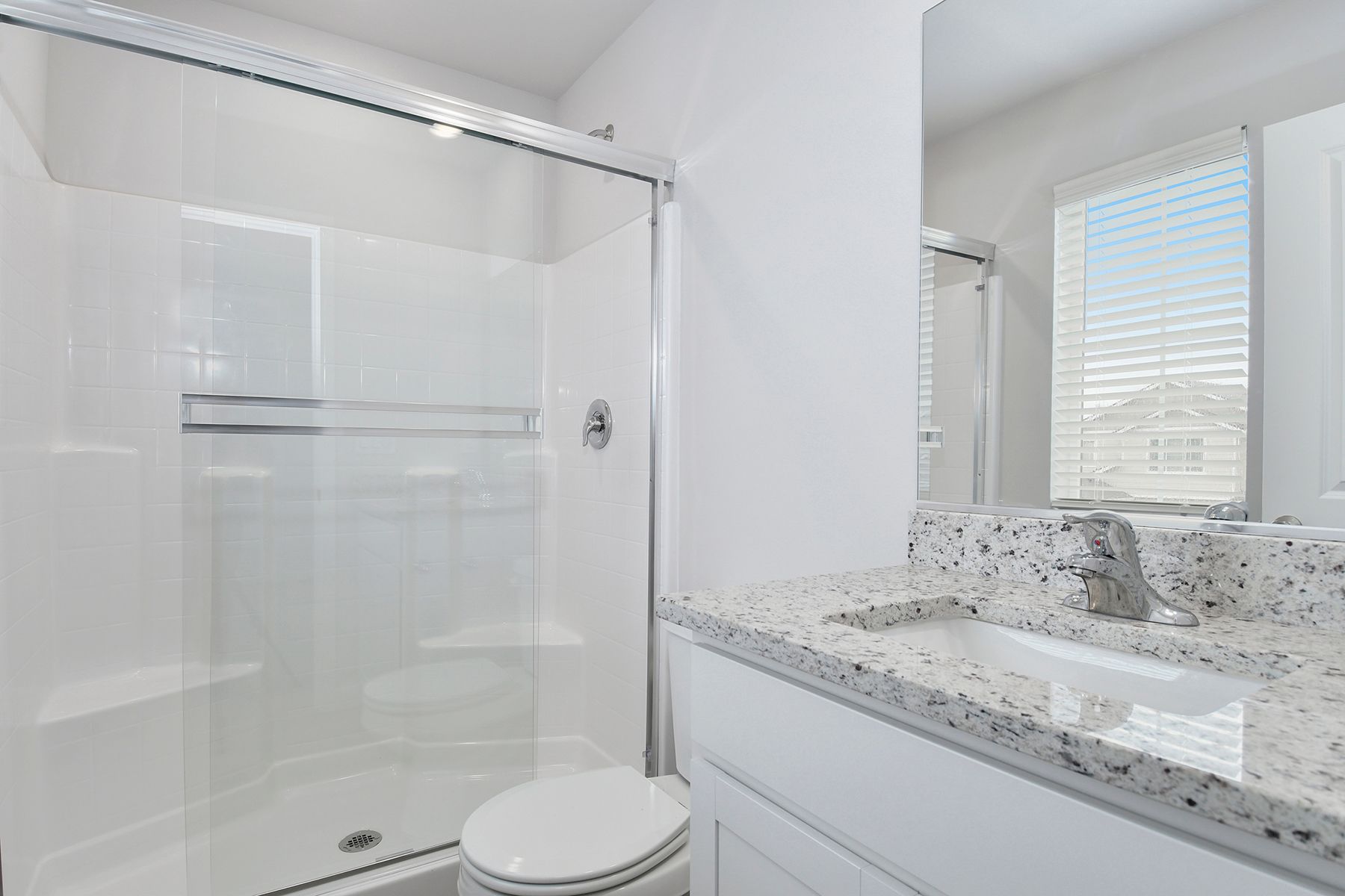 The master bathroom has a large vanity and a step in shower.