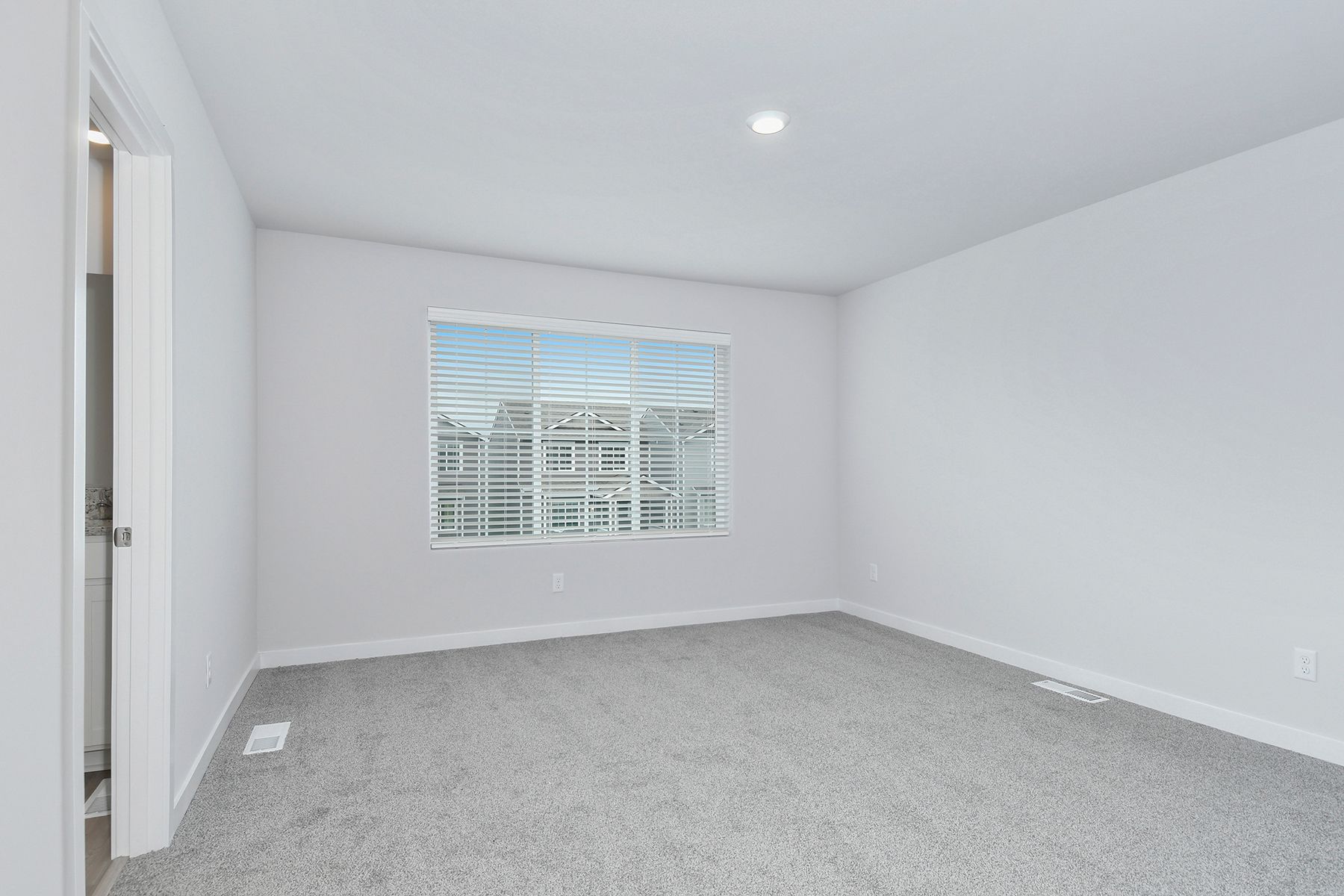 The master bedroom is spacious and has carpet.