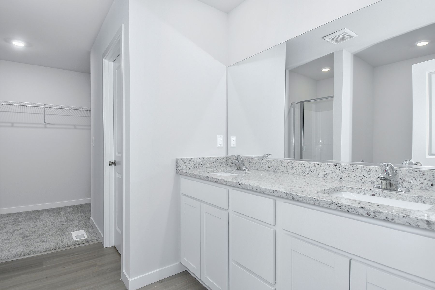 The master bathroom has a dual sink vanity and a step in shower.