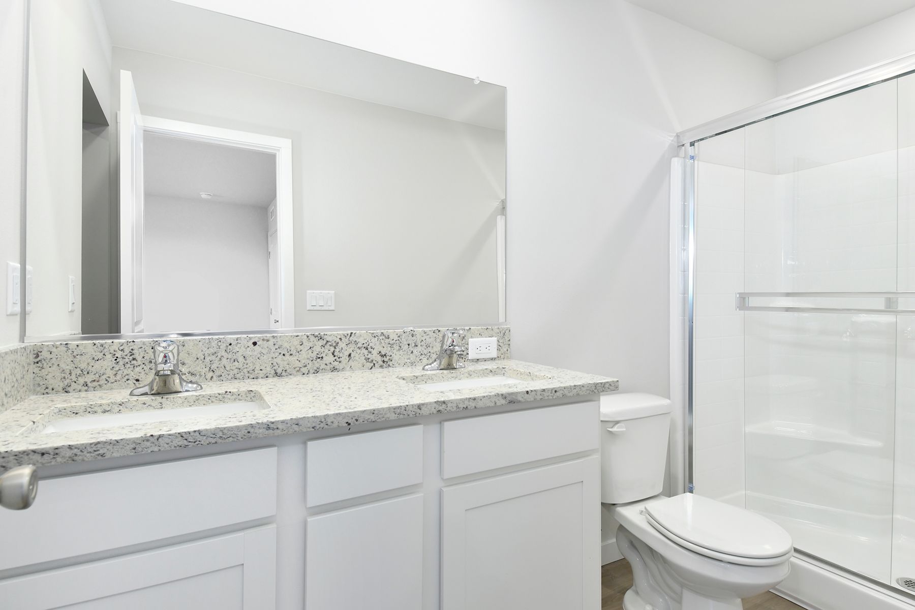 The master bathroom has a dual sink vanity and a step in shower.