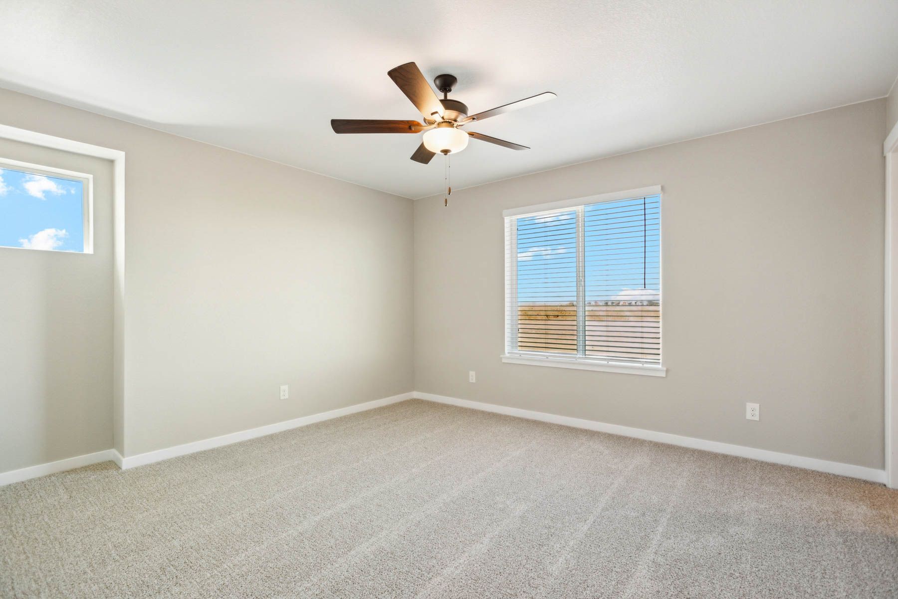 The master bedroom is spacious and has carpet.