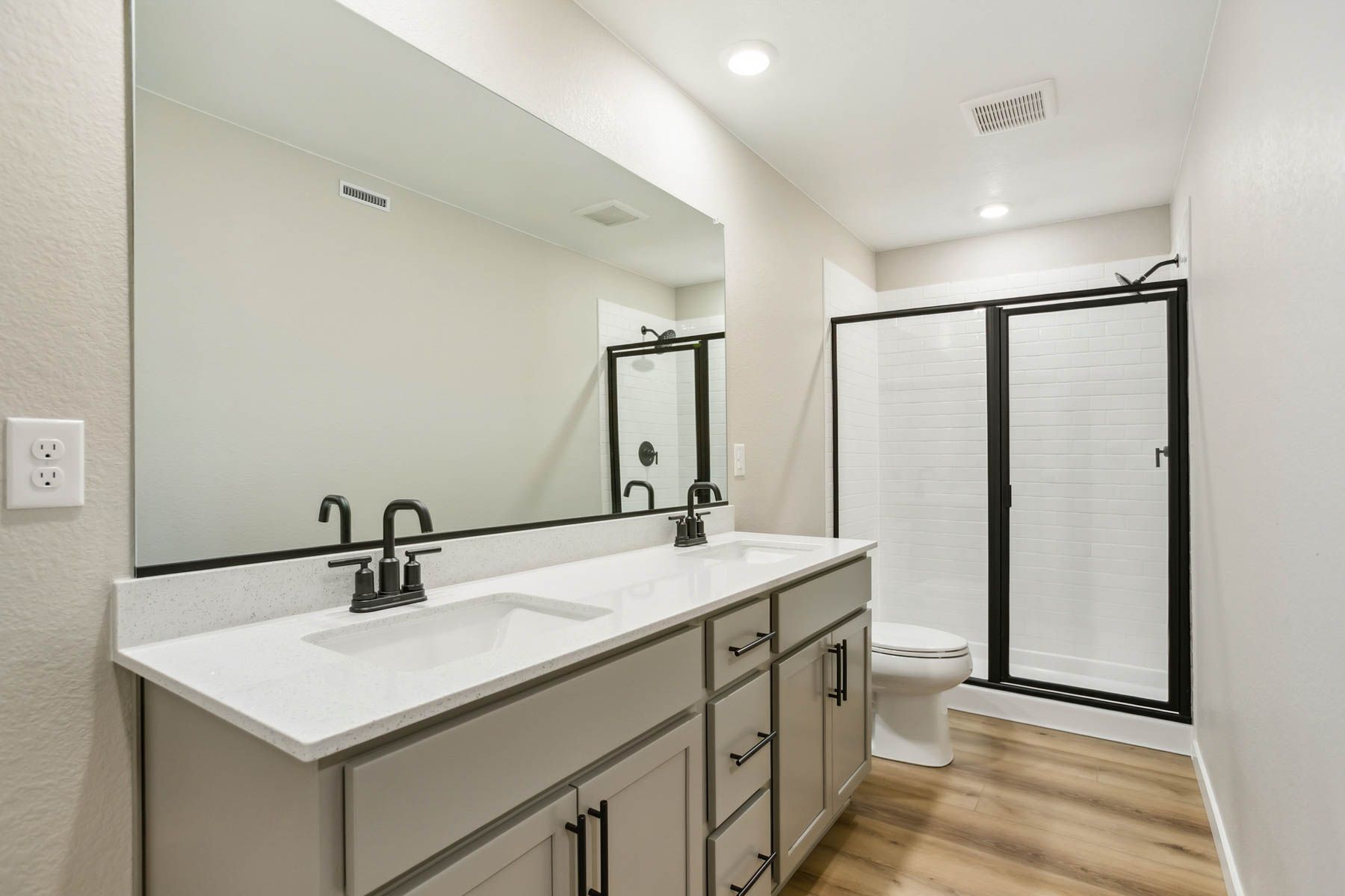 The master bathroom has a dual sink vanity and step in shower.