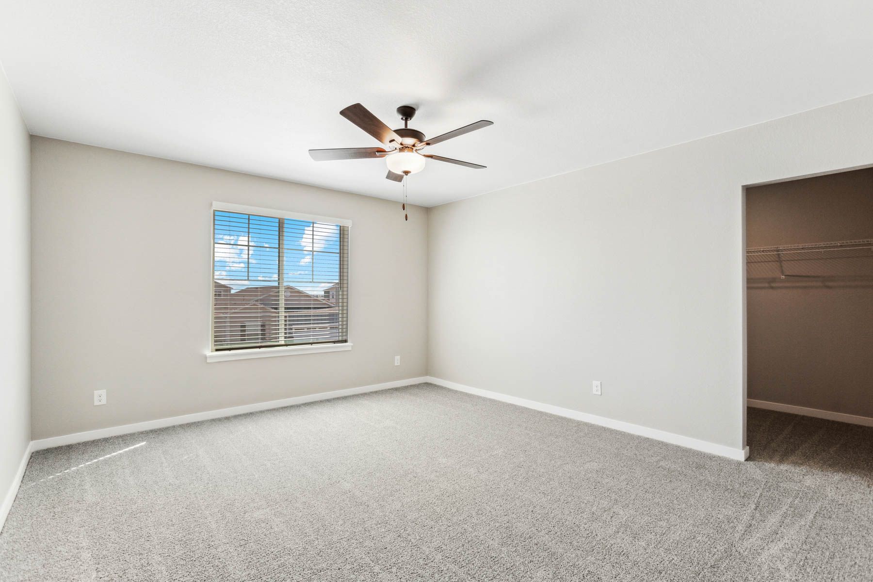 The master bedroom is spacious and has carpet.