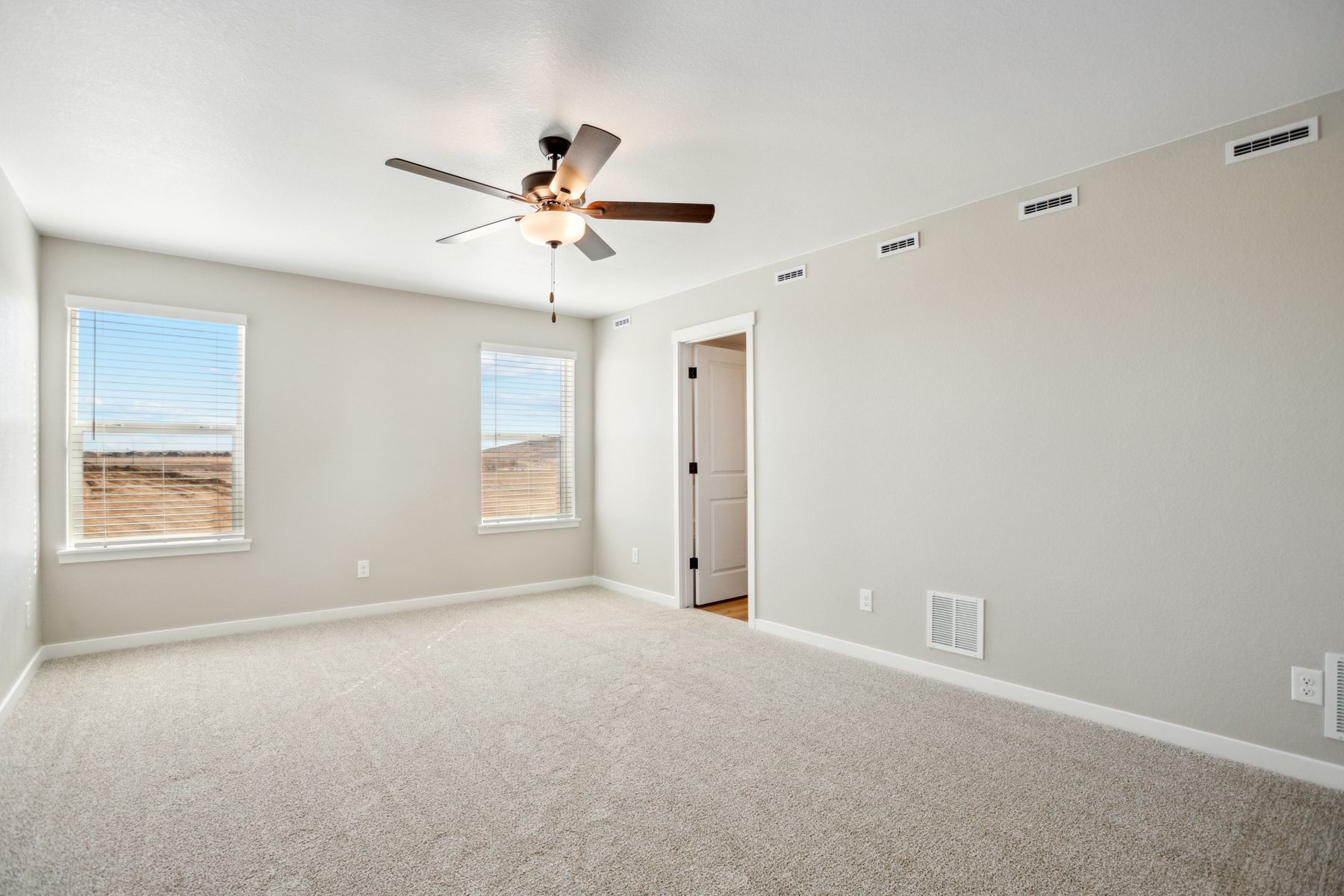 The master bedroom is spacious and has carpet.
