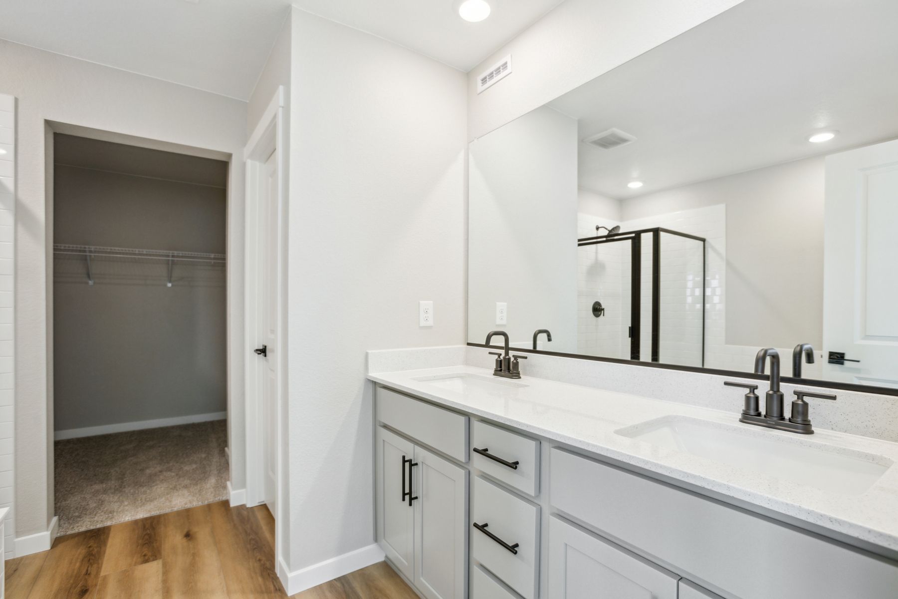 The master bathroom has a dual sink vanity and a step in shower and soaking tub.