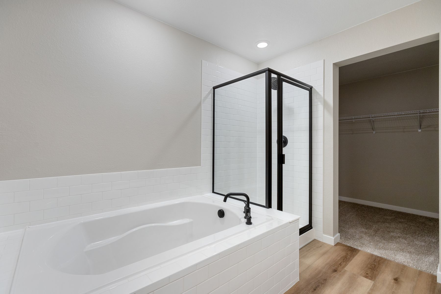 The master bathroom has a dual sink vanity and a step in shower and soaking tub.