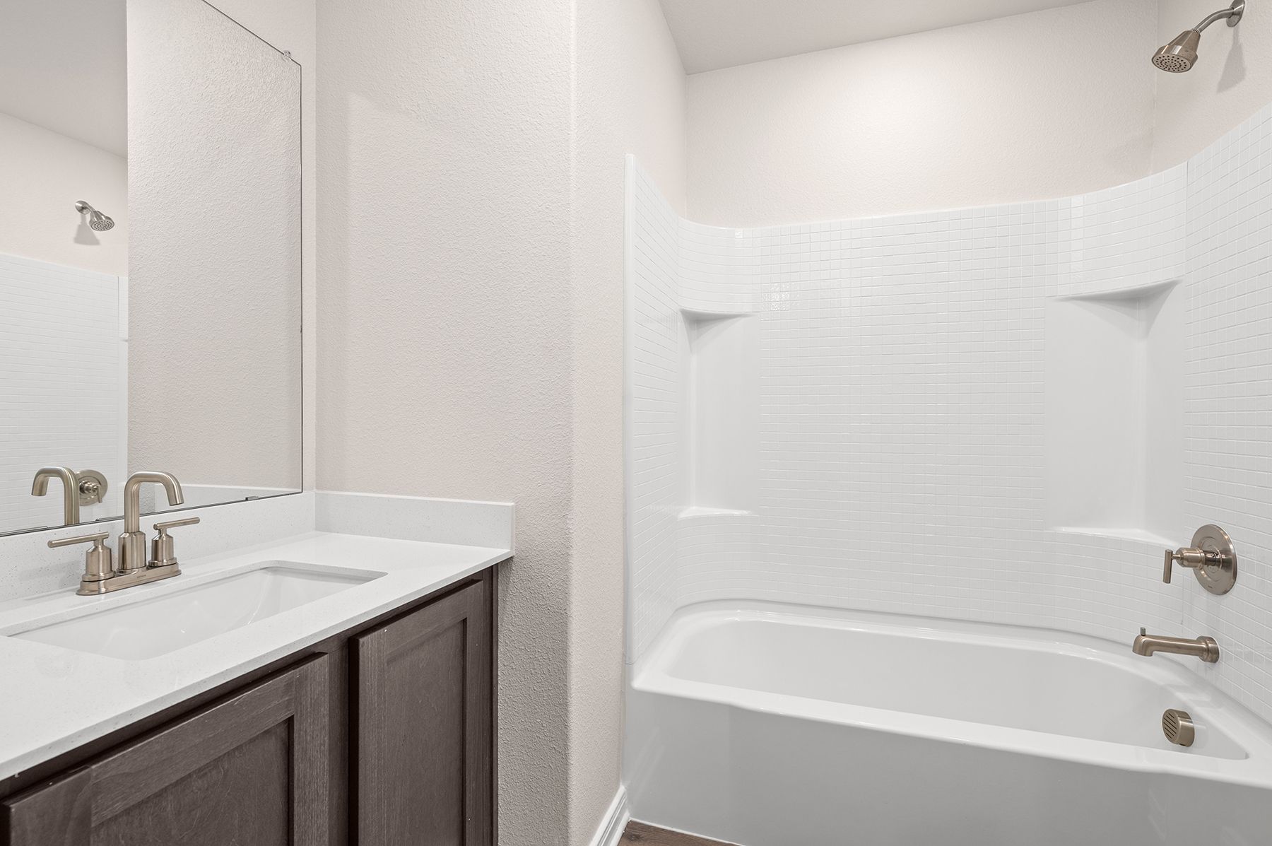 The secondary bathroom has a large vanity space and a shower-tub combo.
