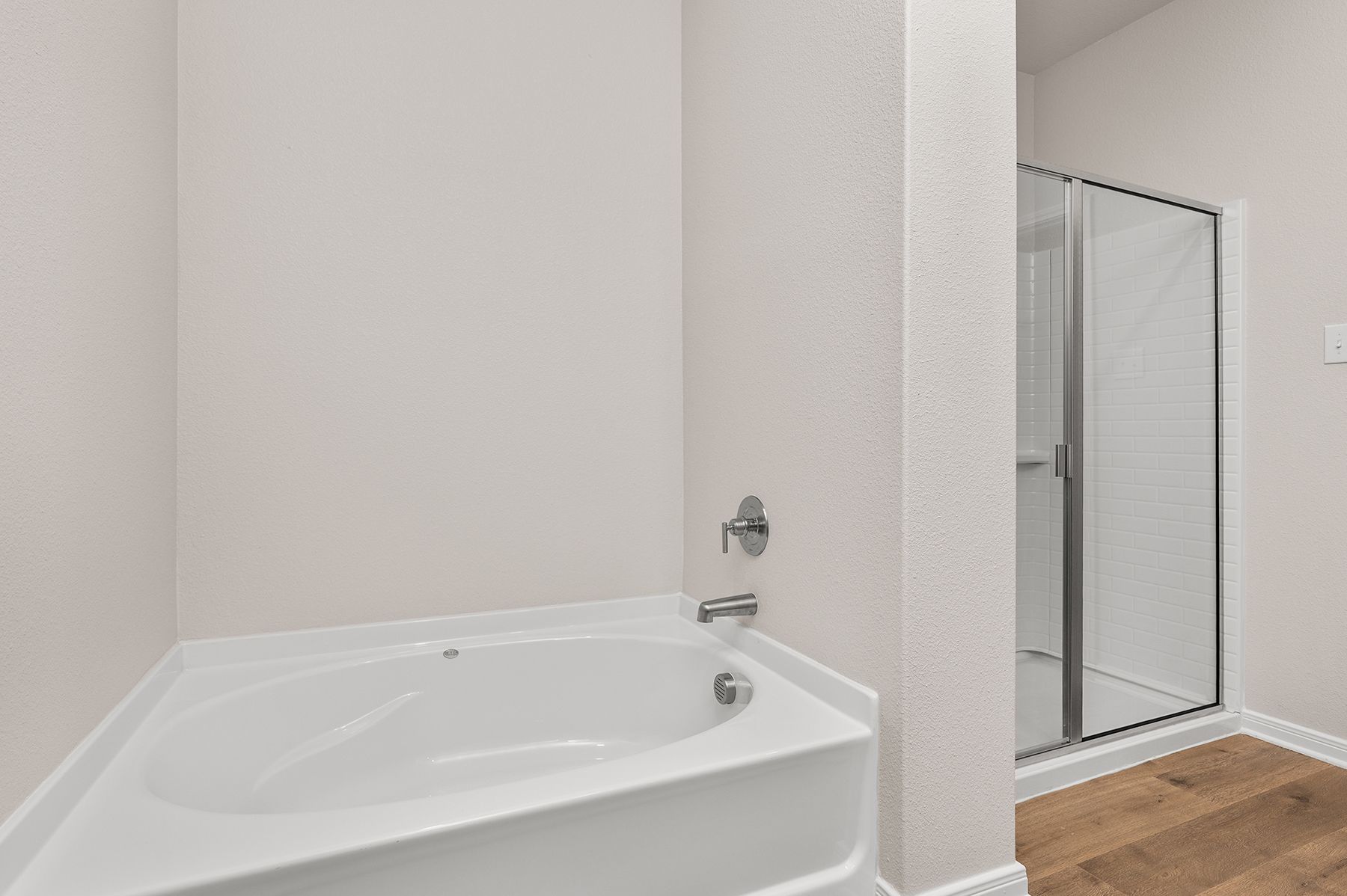 The master bathroom has a large garden tub and a glass, walk-in shower.