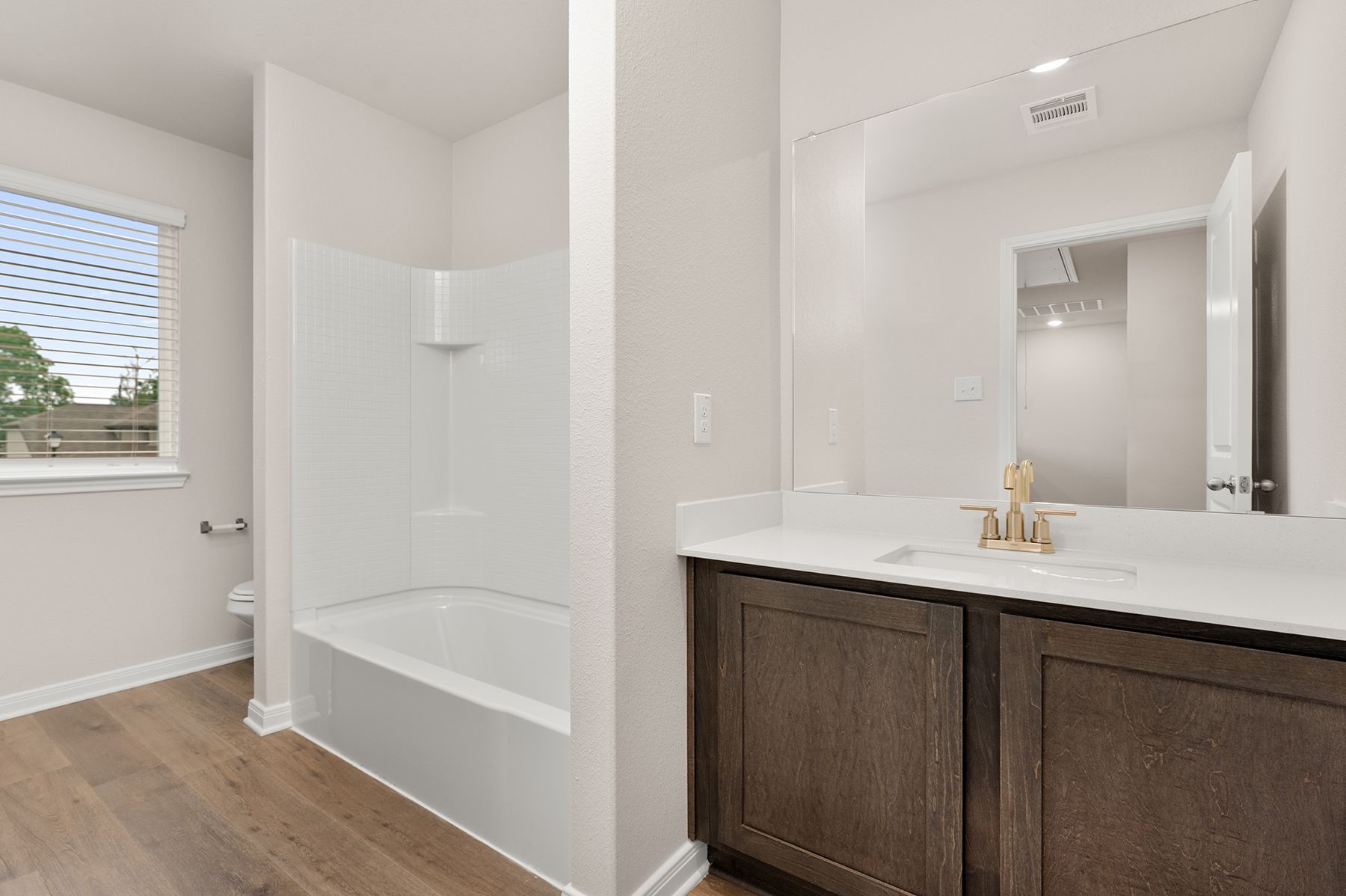 The secondary bathroom of the Cypress has a large vanity and shower-tub combo.