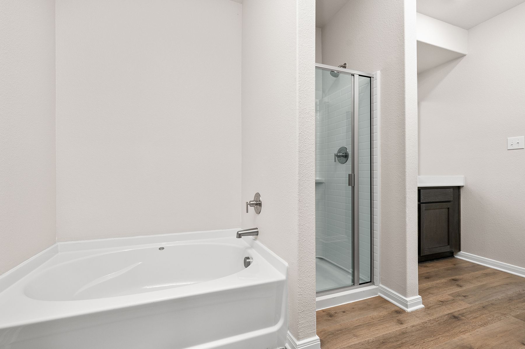 The master bathroom has a glass, walk-in shower and a garden tub.