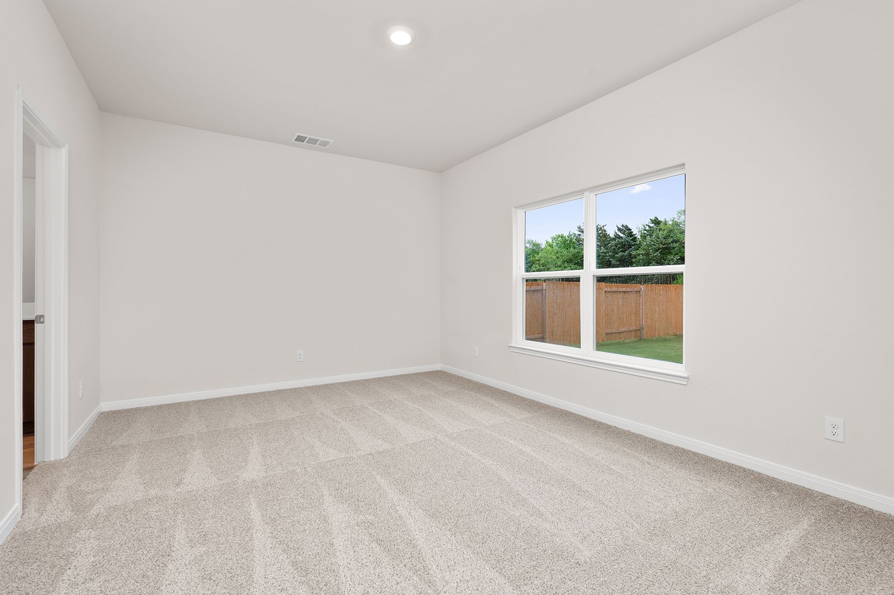 The master bedroom is spacious with a large window.