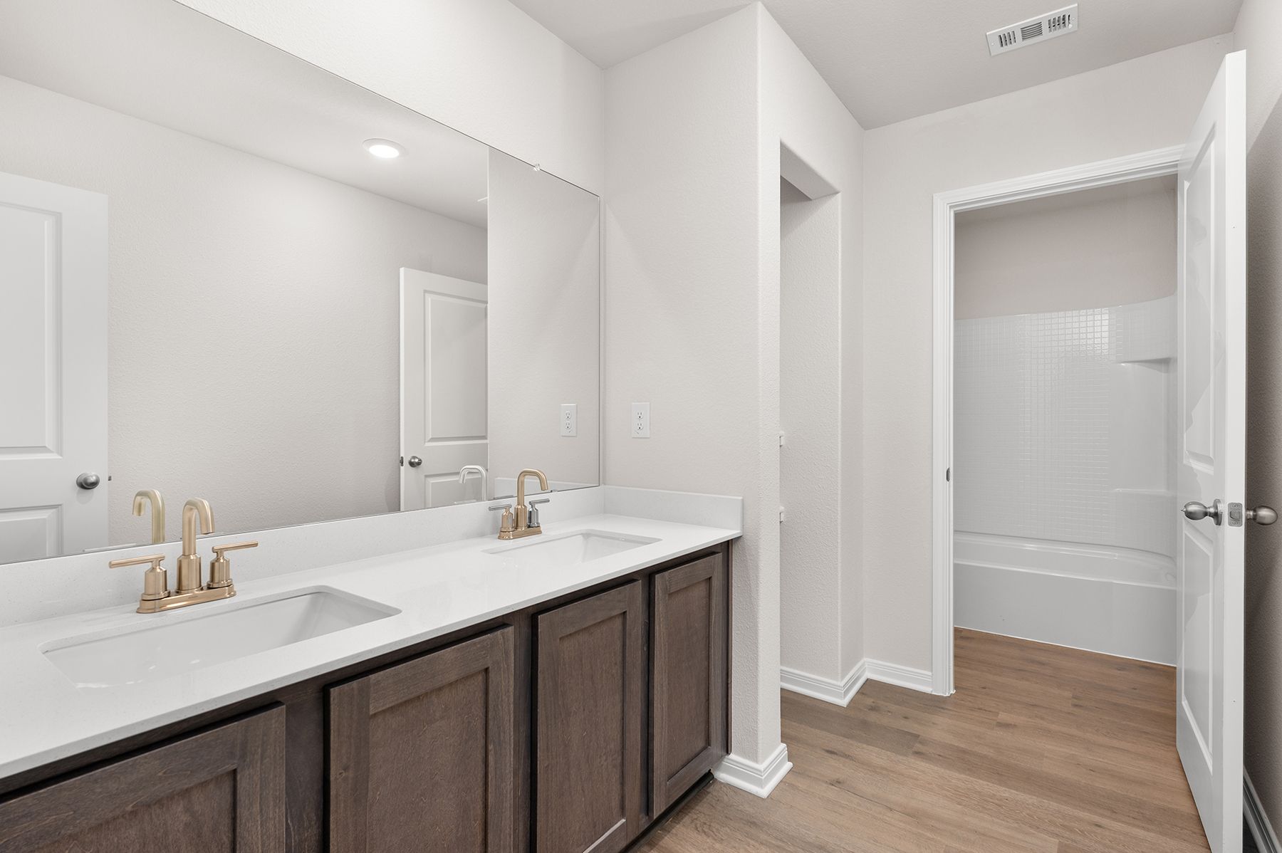 The secondary bathroom has a large vanity space and a shower-tub combo.