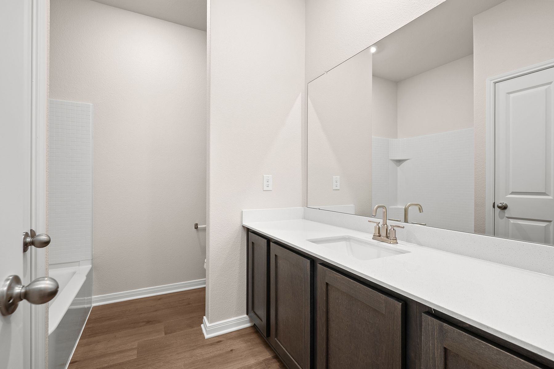 The secondary bathroom has a large vanity space and a shower-tub combo.