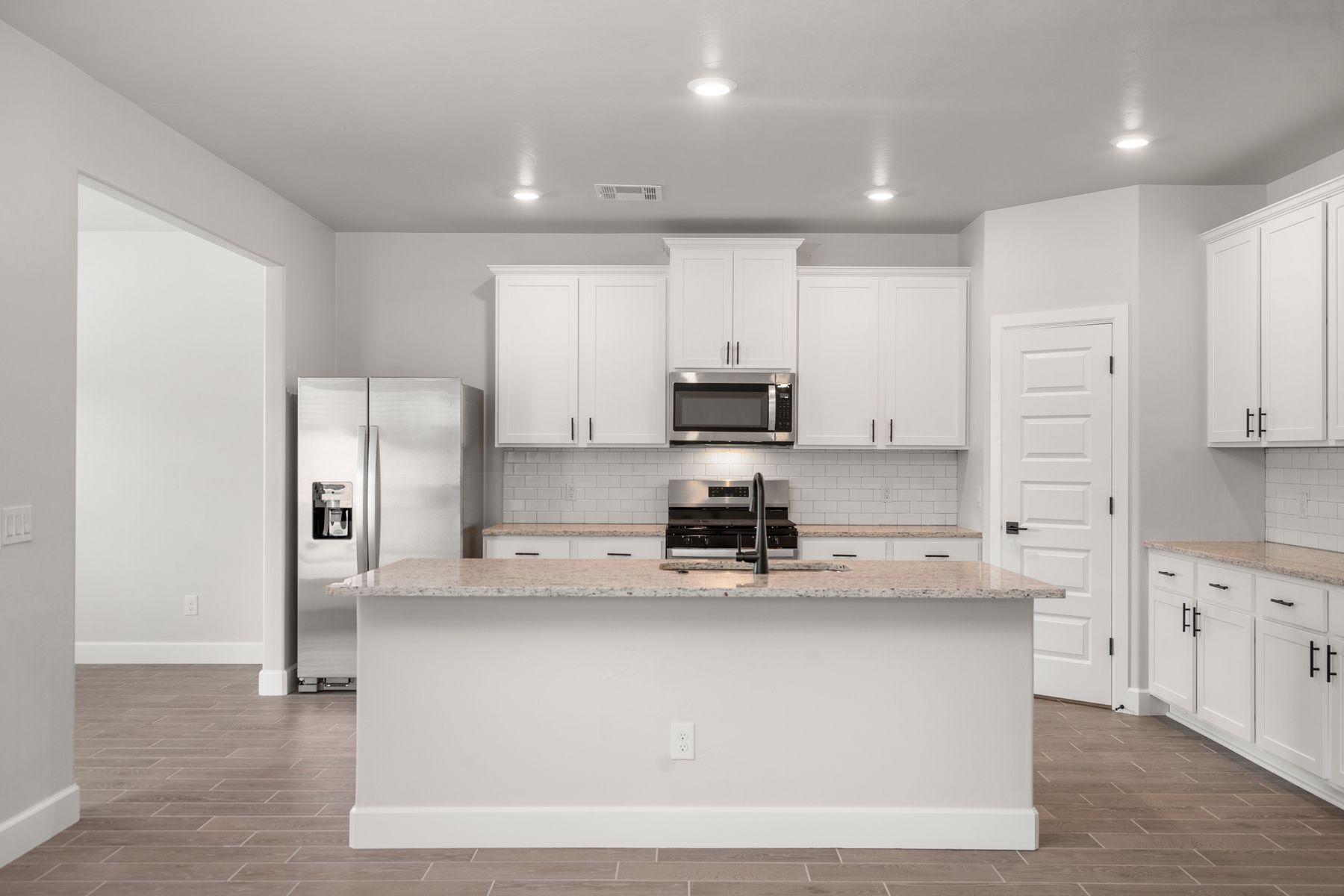 The kitchen has a large island with granite countertops.