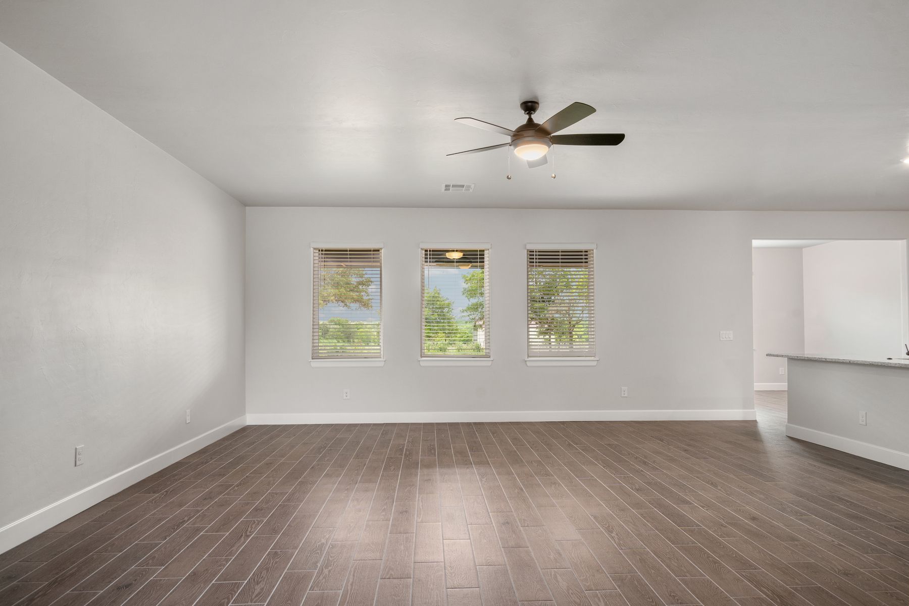 The large family room has large windows and plenty of space for furniture.