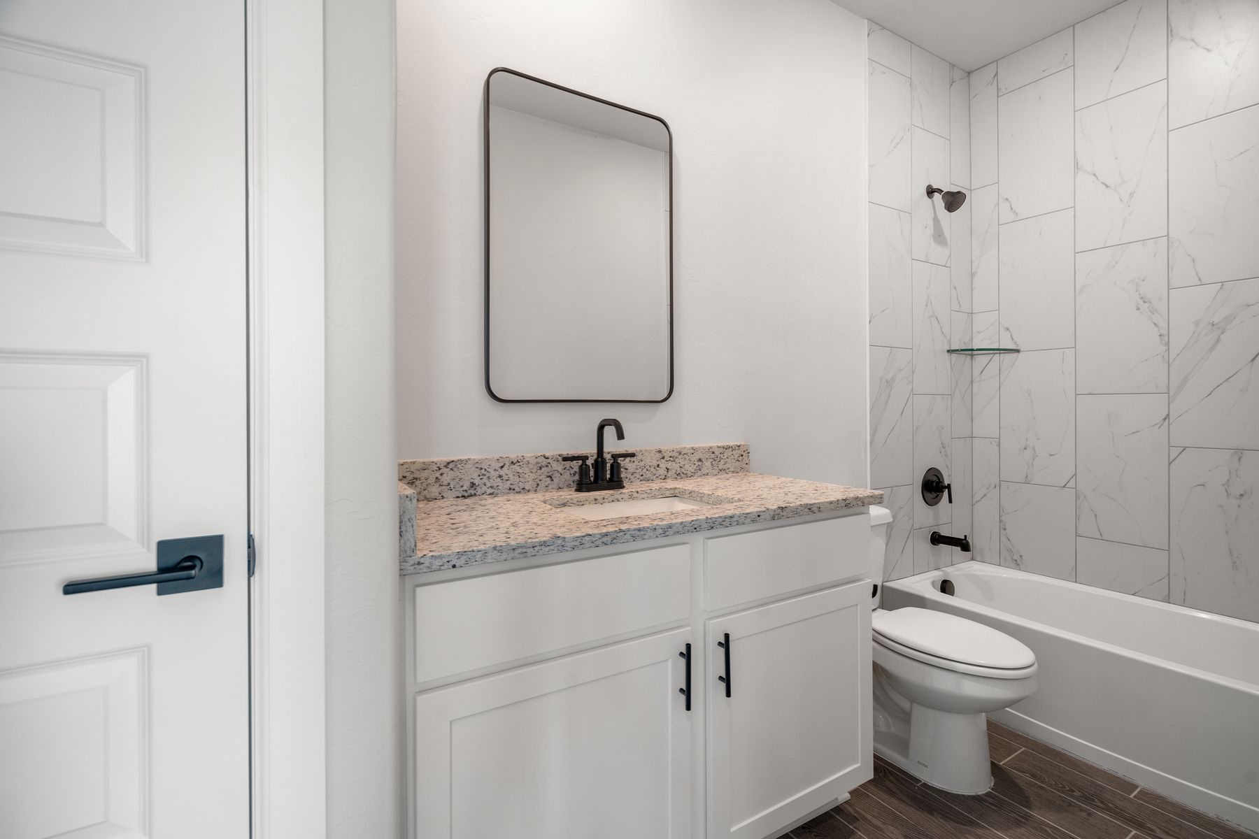 The secondary bathroom has a great vanity space and a tile shower-tub combo.
