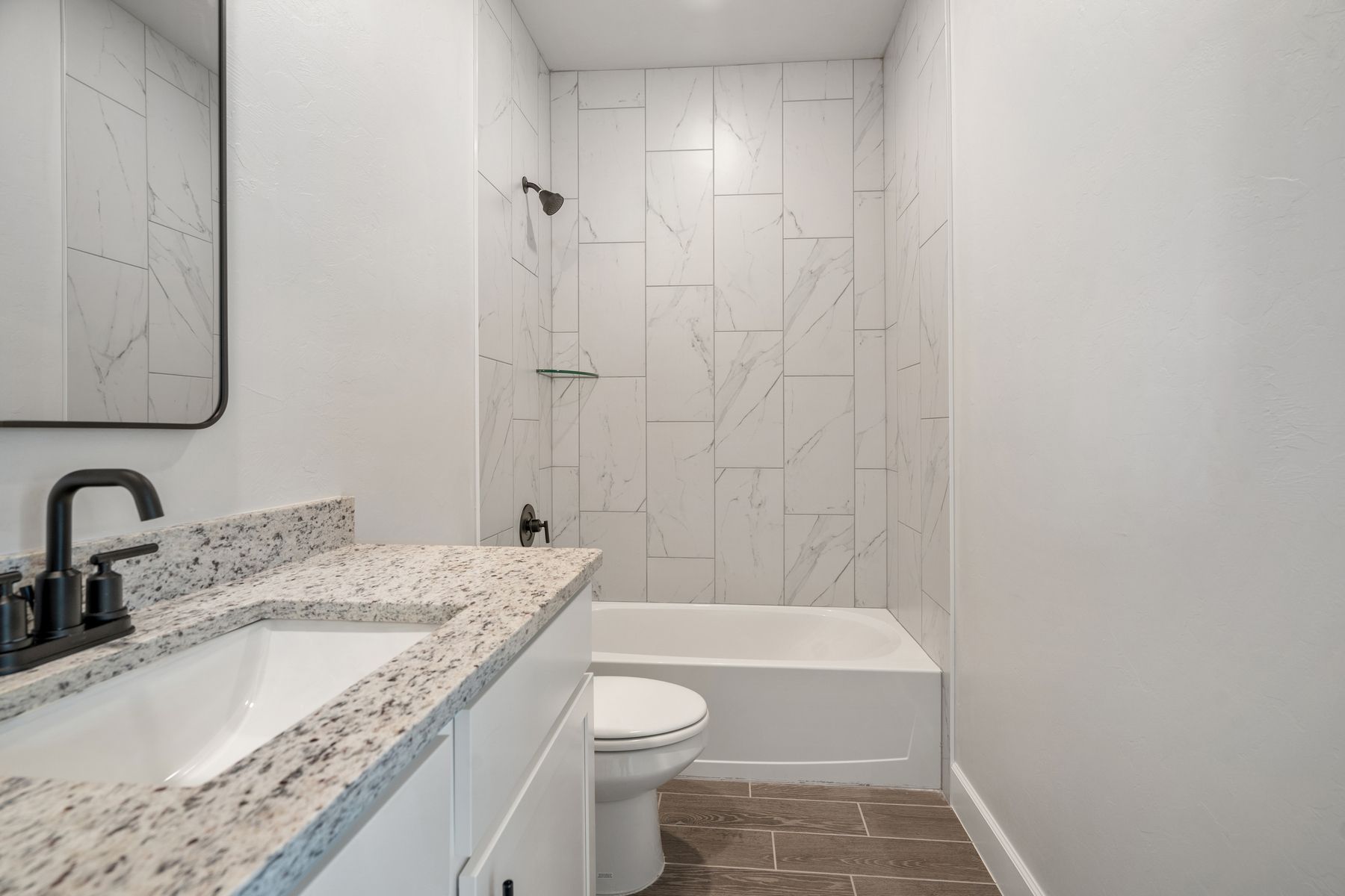 The secondary bathroom has a great vanity space and a tile shower-tub combo.