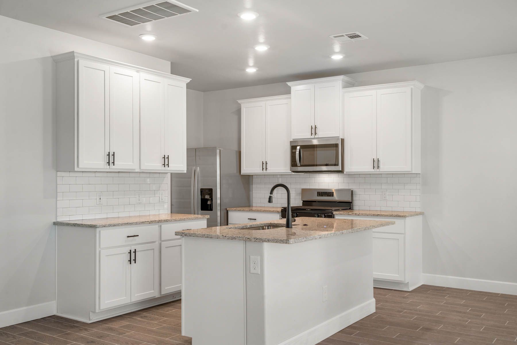 The upgraded kitchen has a large kitchen island with granite countertops.