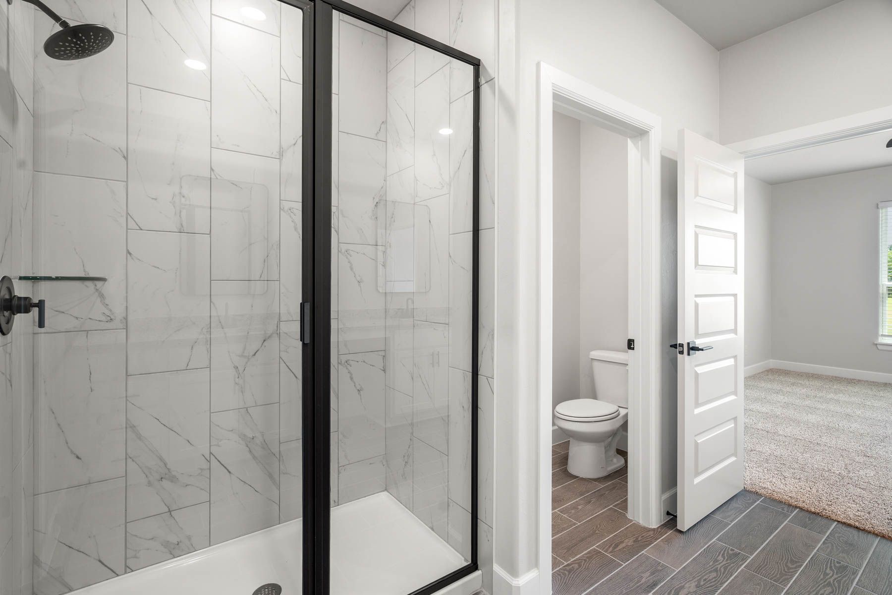 The master bathroom has a walk-in, glass shower and private toilet room.