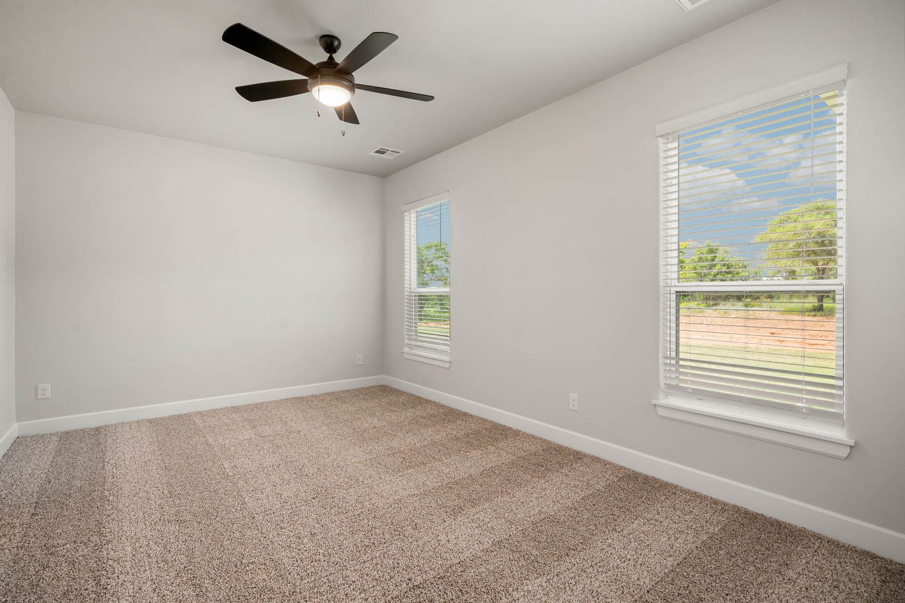 The master bedroom is spacious and has large windows.