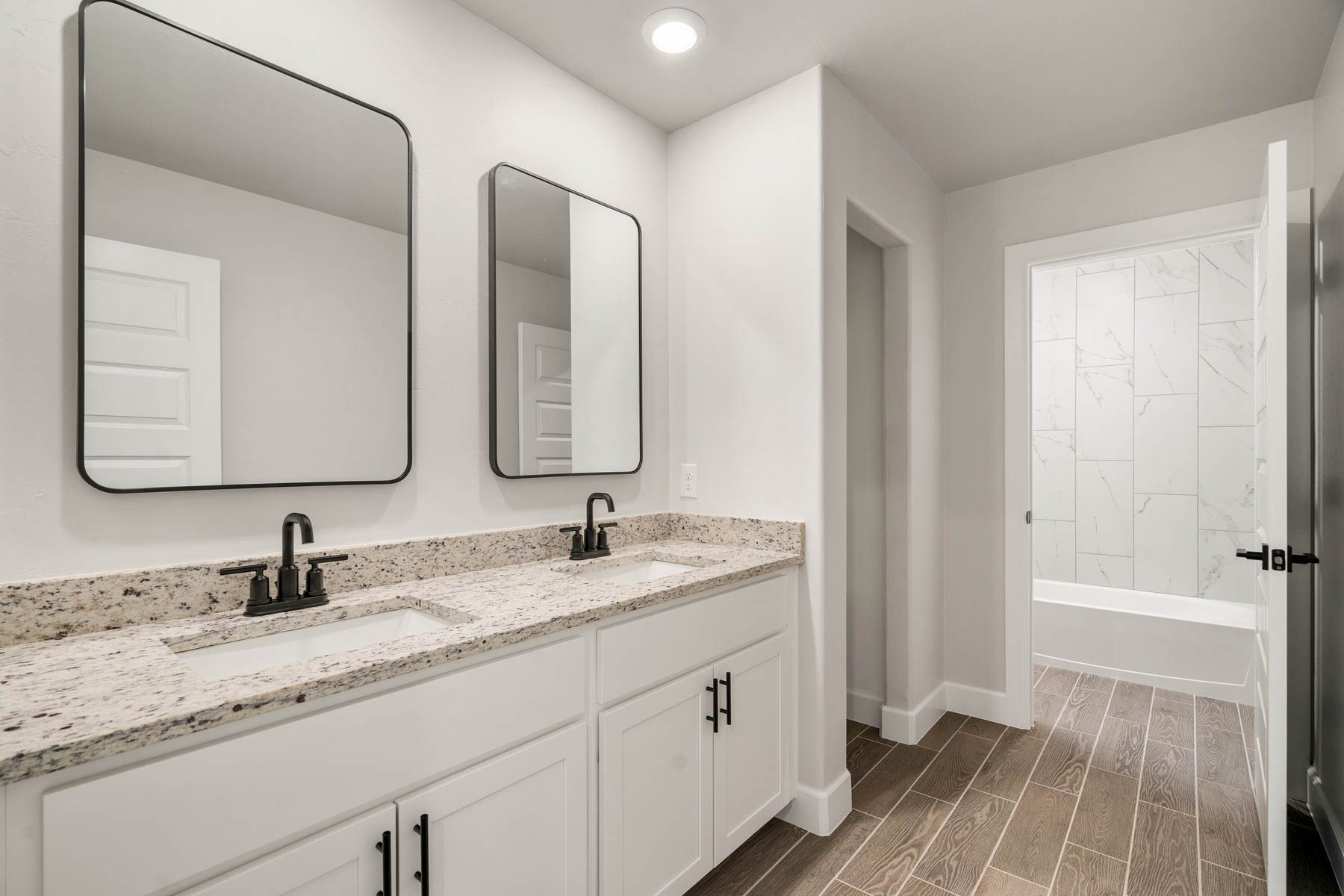 The secondary bathroom has a large vanity and shower tub combo.