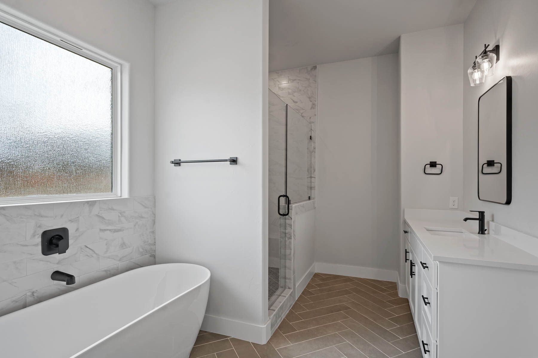 The master bathroom has a large vanity, glass walk-in shower and a large free-standing tub.