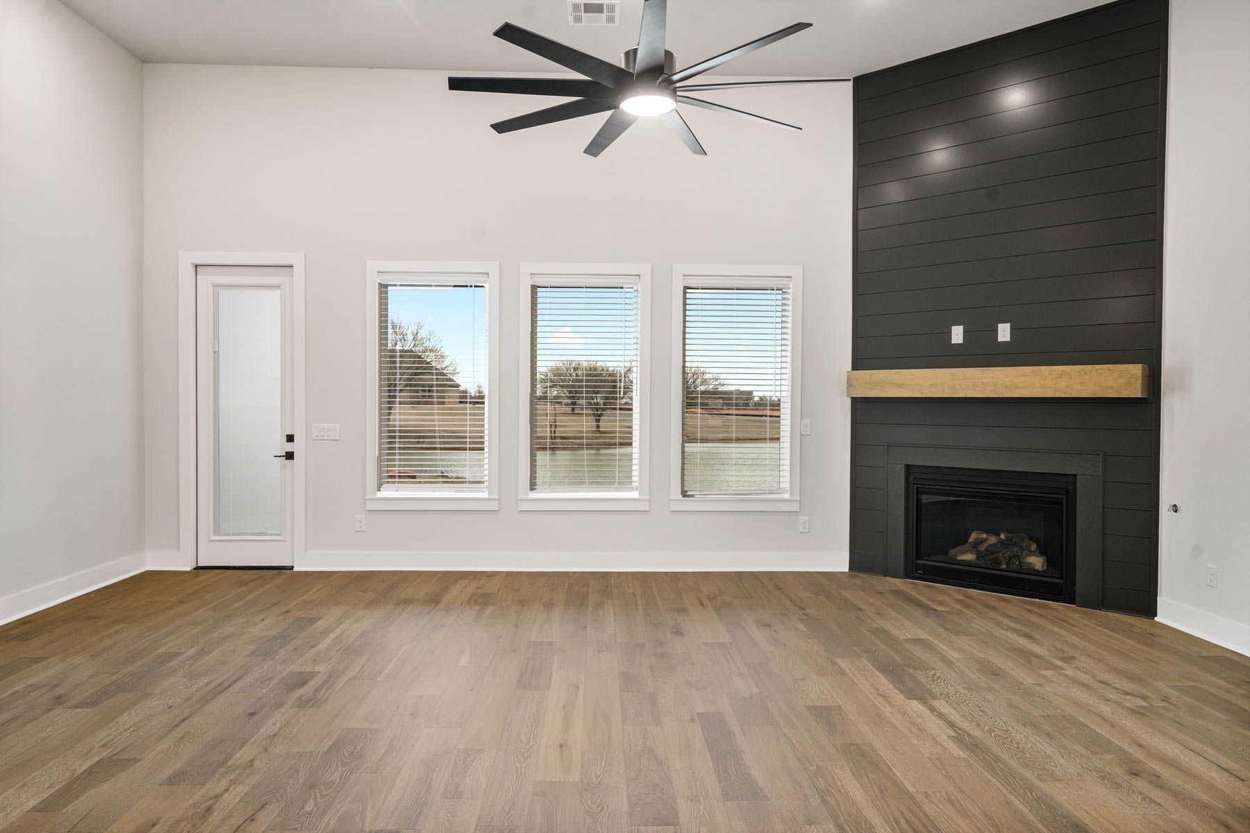 The family room of the Hefner has a fireplace and large windows.