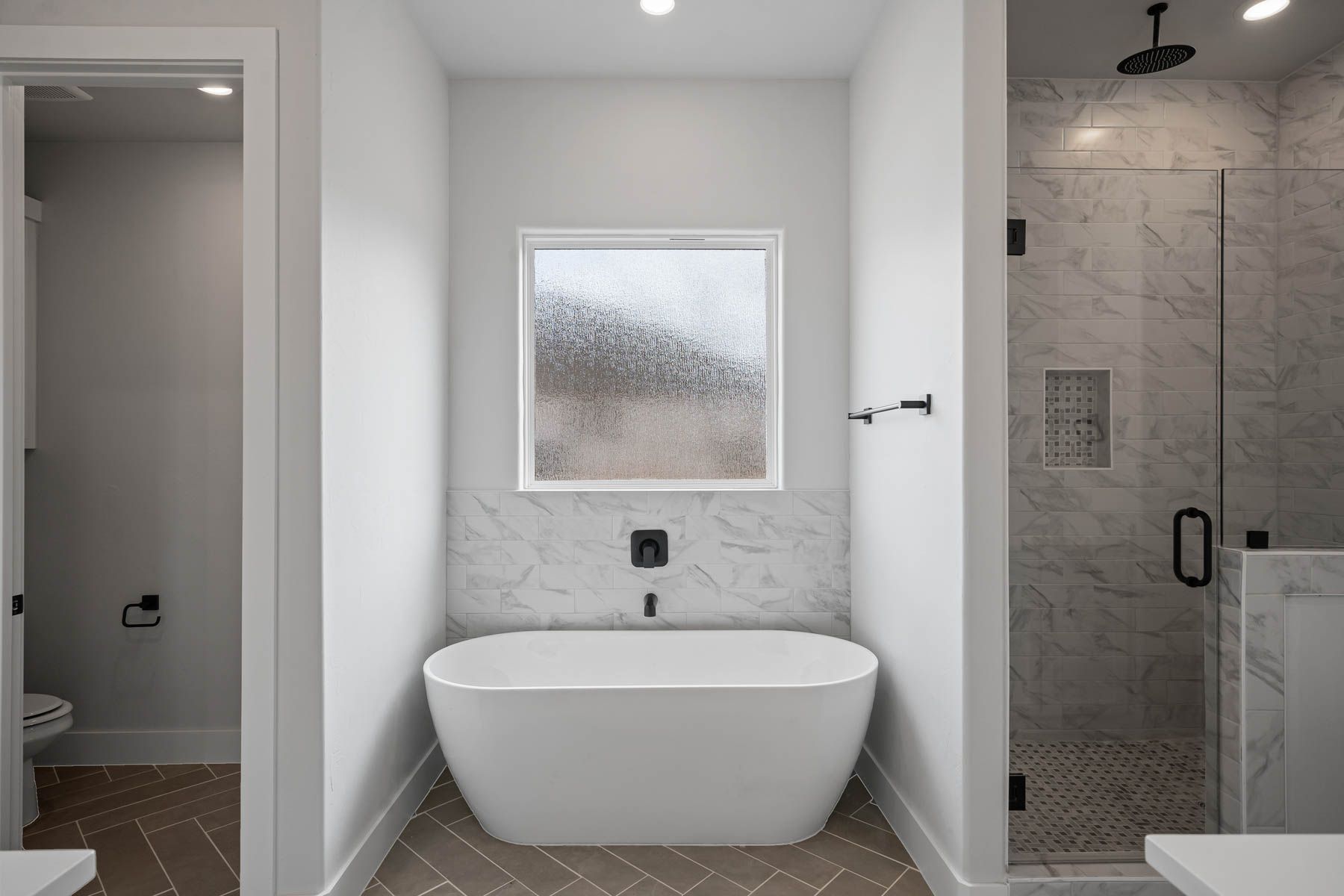 The master bathroom has a glass, walk-in shower and a large free-standing tub.