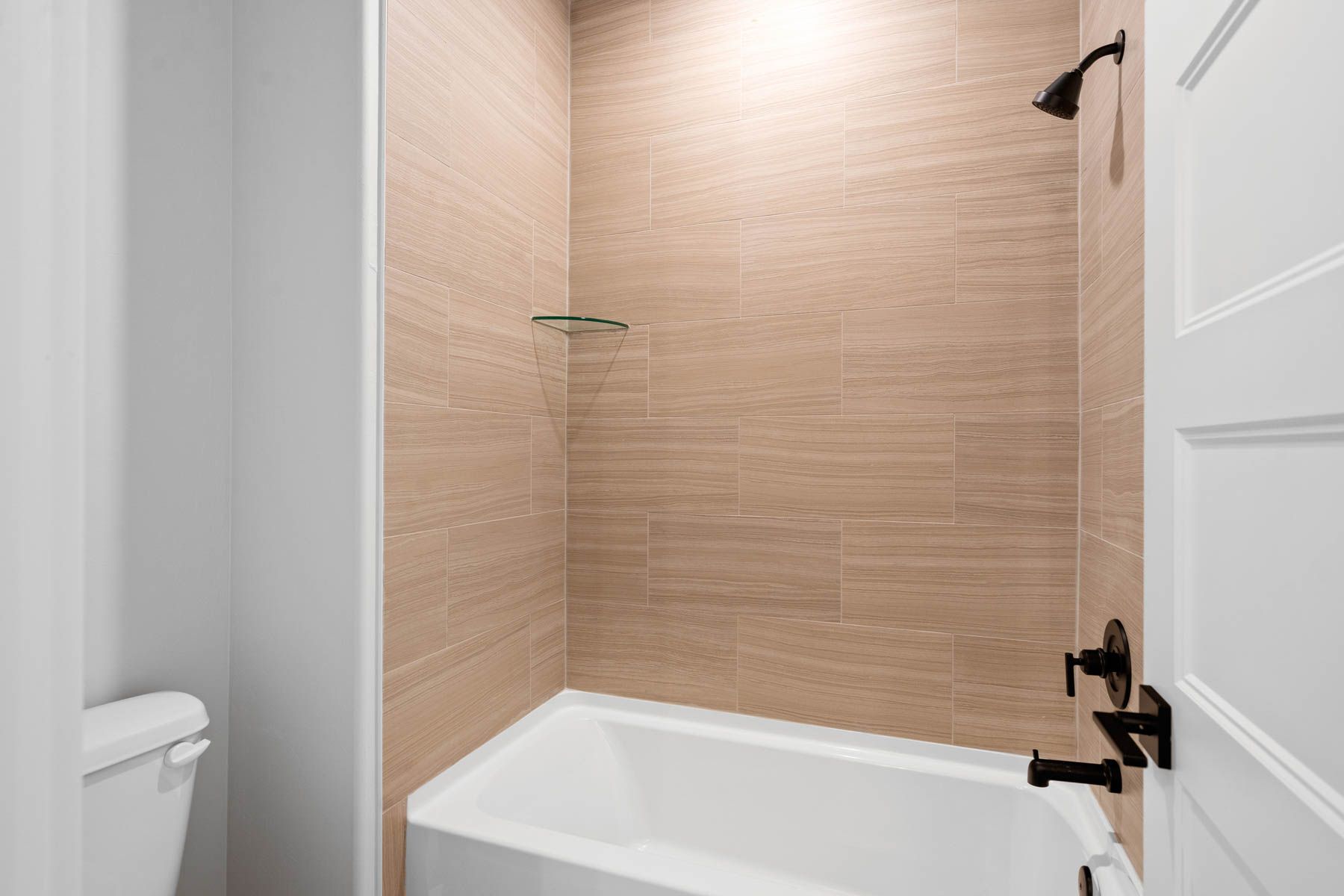 The secondary bathroom has a tiled shower-tub combo.