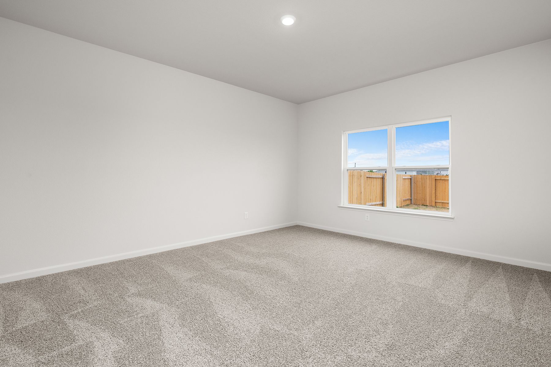 The master bedroom has a large window that lets in natural light and backyard views.