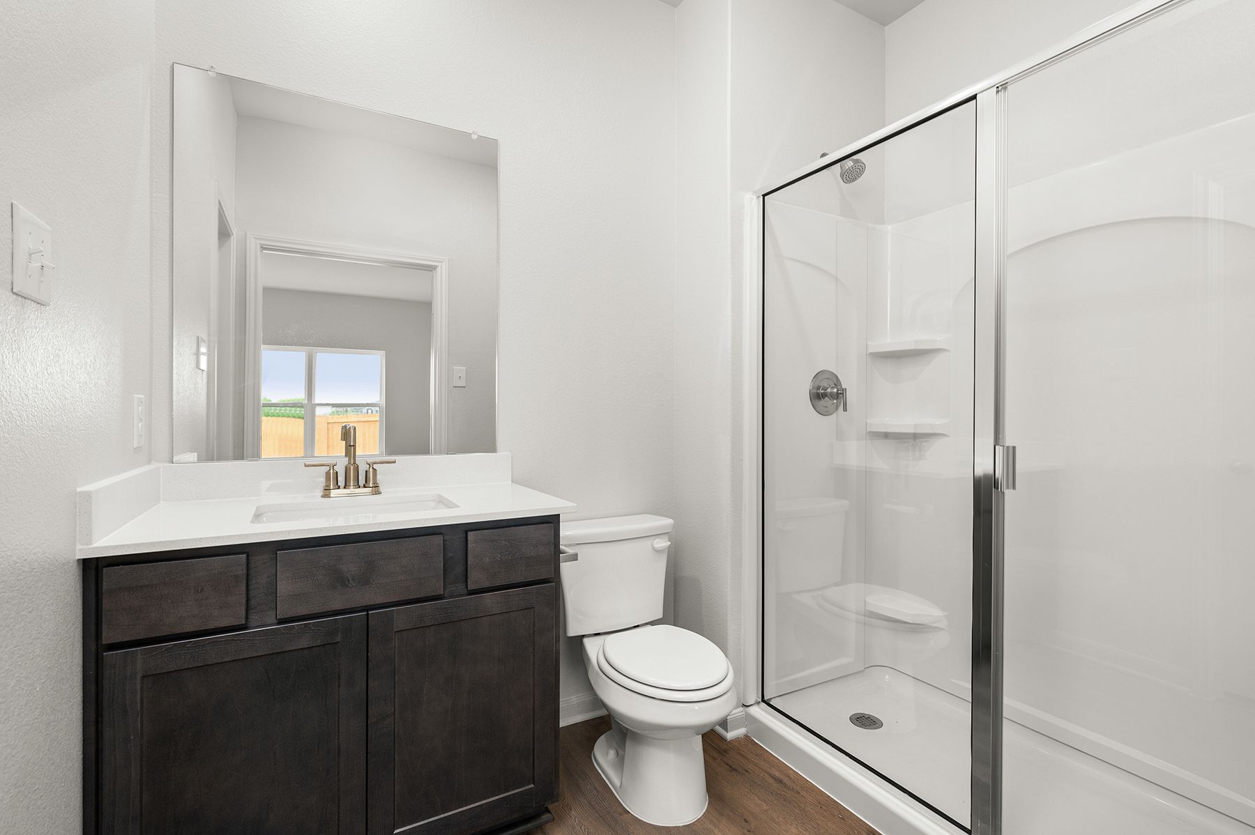 The master bathroom has a large vanity space and a glass, walk-in shower.