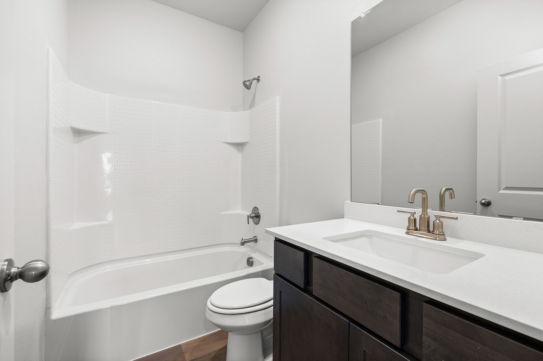 The secondary bathroom has a spacious vanity and a shower-tub combo.