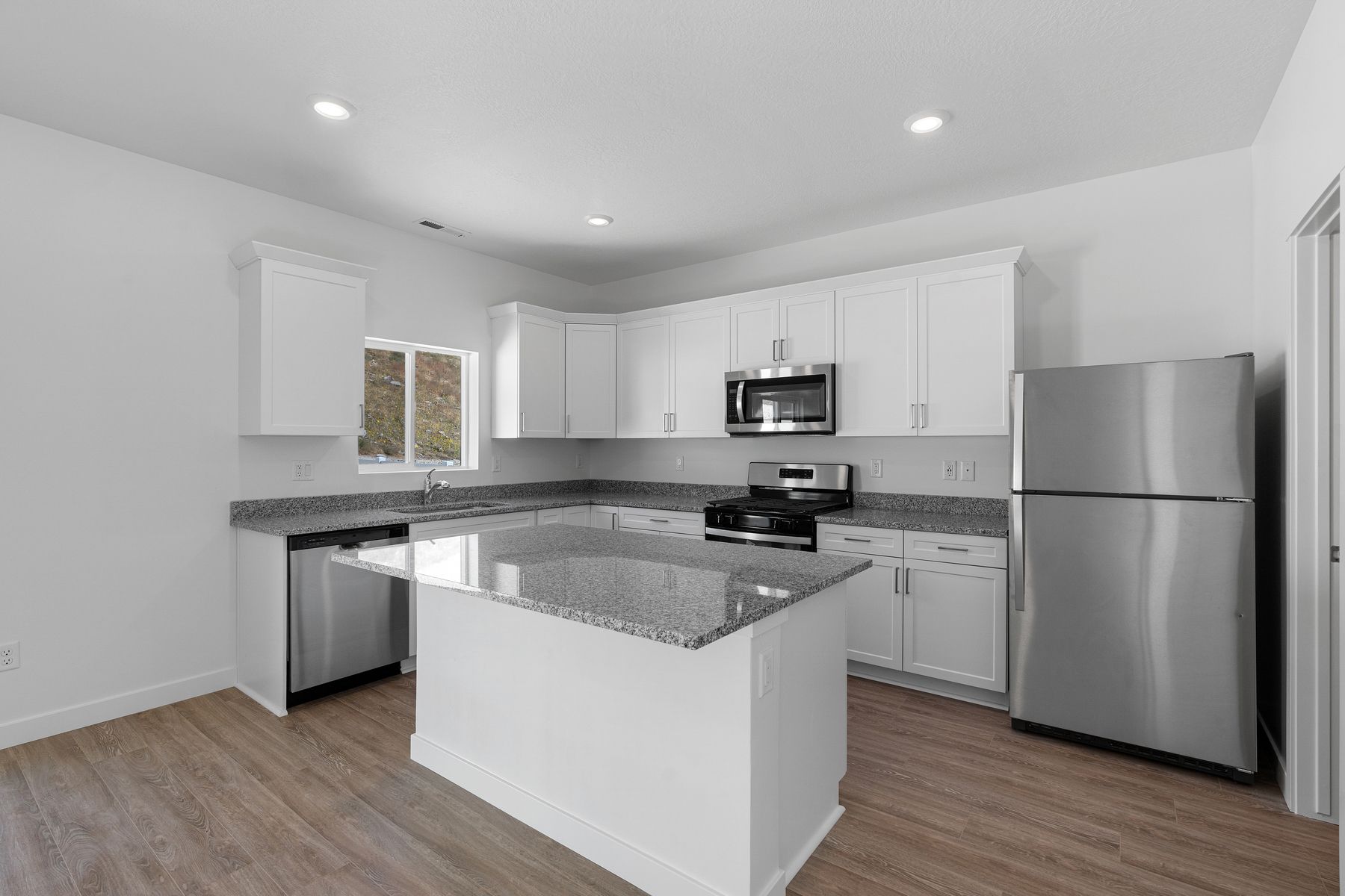 The kitchen has white wood cabinetry.