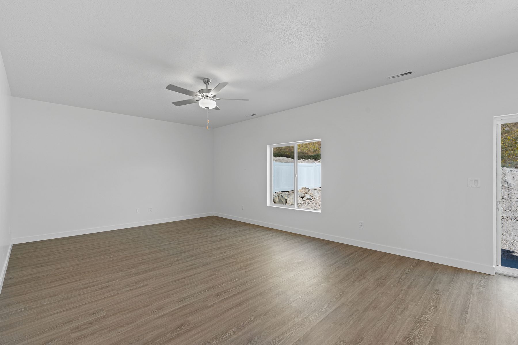 The family room is spacious and has a large window that lets in backyard views.