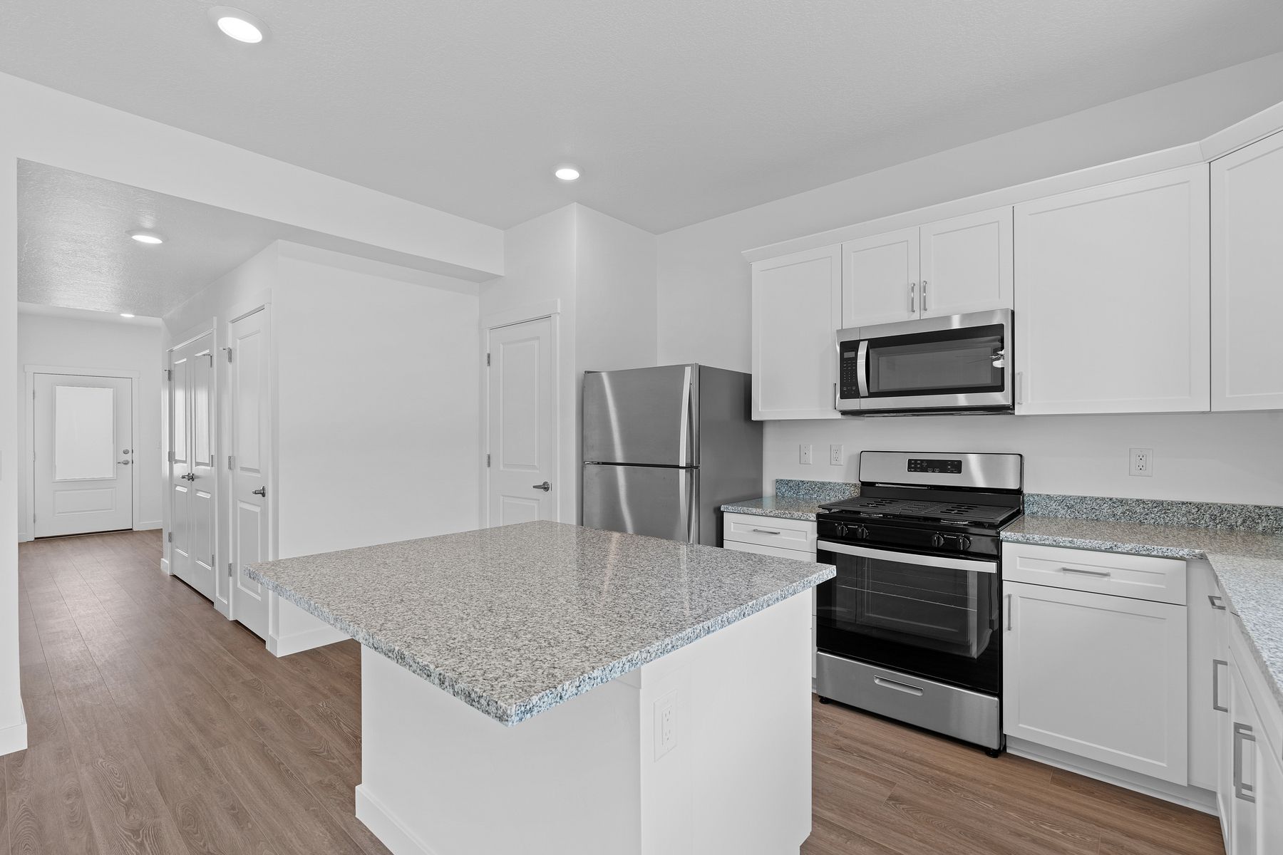 The kitchen has sprawling granite countertops. 